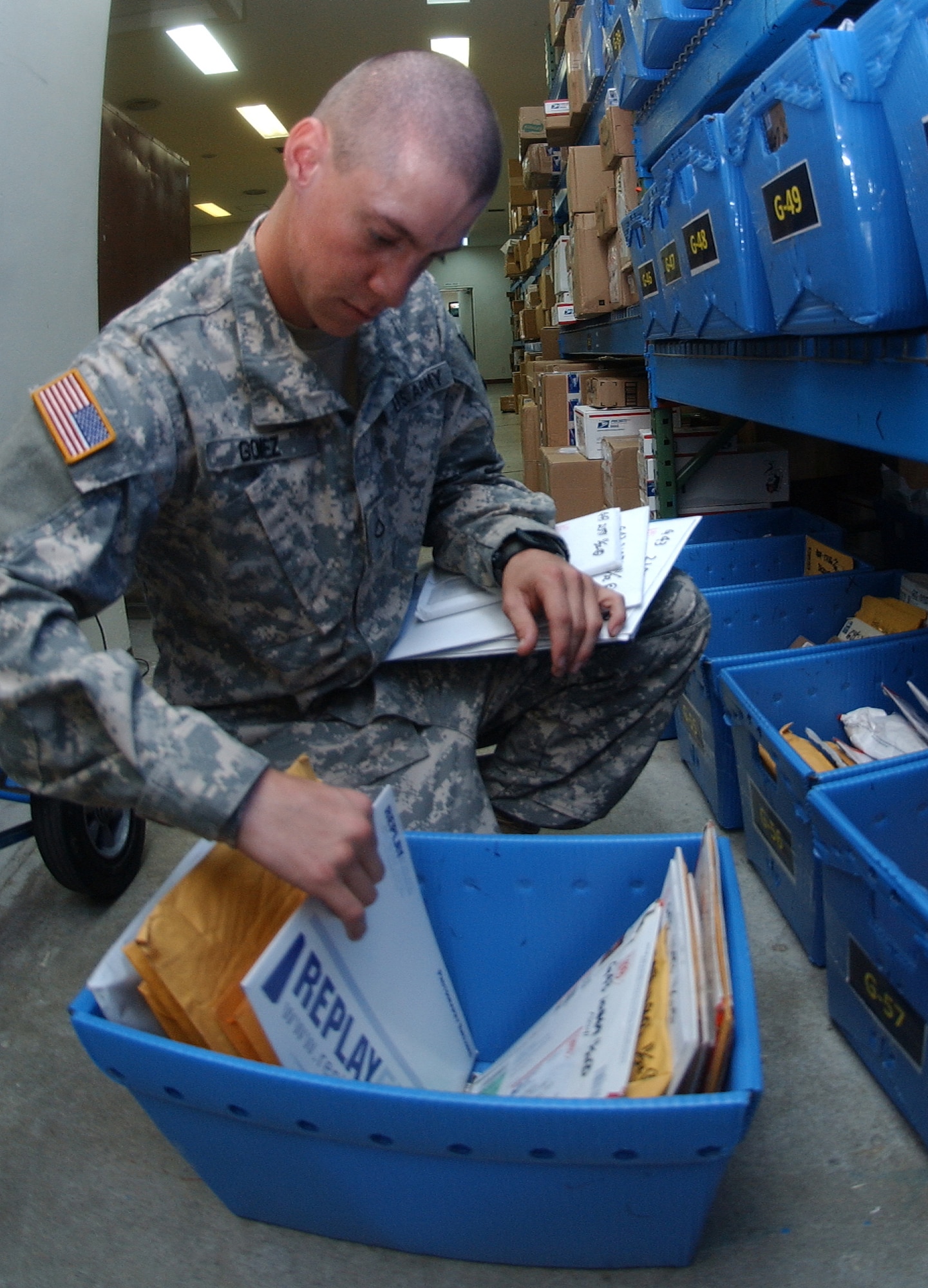 Army Private 1st Class Juan Gomez, C1-1 Air Defense Artillery, sifts through a mail basket to retreive a customer's package Nov. 23. PFC Gomez is one of several soldiers who volunteer at postal service center 80 during the holiday season. Beginning Nov. 30, the postal service center staff will need more volunteers to help with holiday season mail surge through Dec. 24. Call 634-4240 for more information on volunteer requirements. (U. S. Air Force photo/Staff Sgt. Jason Lake) 