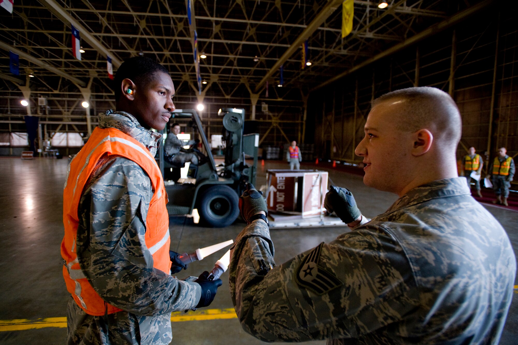 MISAWA AIR BASE, Japan -- Staff Sgt. Jacob Showalter, 35th Logistics Readiness Squadron inbound cargo supervisor, explains spotting techniques to Airman 1st Class Gregory Staton, 35th Civil Engineer Squadron carpentry apprentice, during cargo deployment function training Nov. 20 at Hanger 949. The mission of the CDF is to process the base's outbound cargo during deployment. Airman Staton has been with the CDF team for seven months. (U.S. Air Force photo/Senior Airman Jamal D. Sutter)