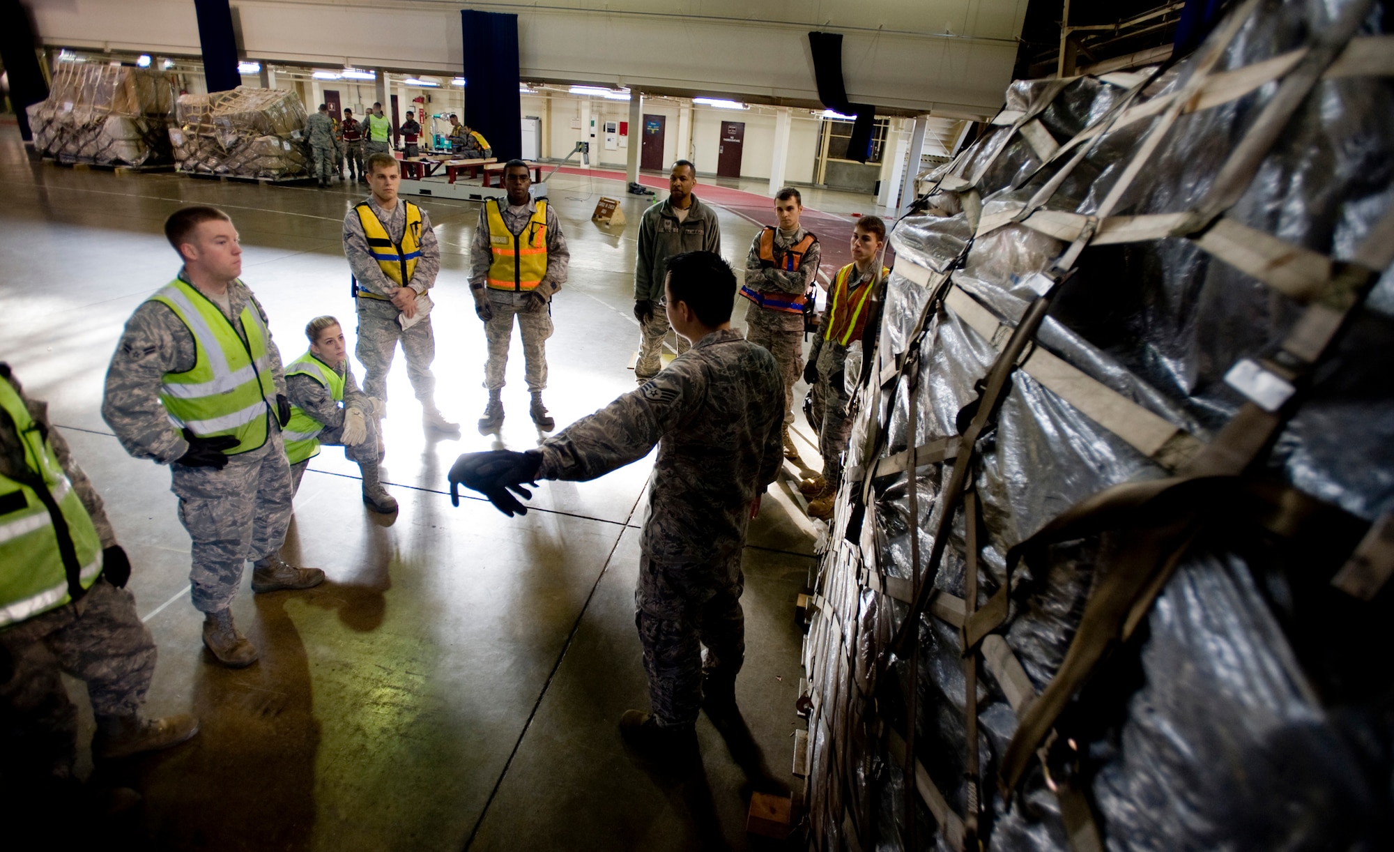 MISAWA AIR BASE, Japan -- Members of a cargo deployment function discuss pallet build-up procedures during training Nov. 20 at Hangar 949. In preparation for deployments, the CDF ensures pallets are properly built and labeled, and the team is responsible for loading cargo to transport aircraft. Seventy-two Airmen from various squadrons make up the team. (U.S. Air Force photo/Senior Airman Jamal D. Sutter)