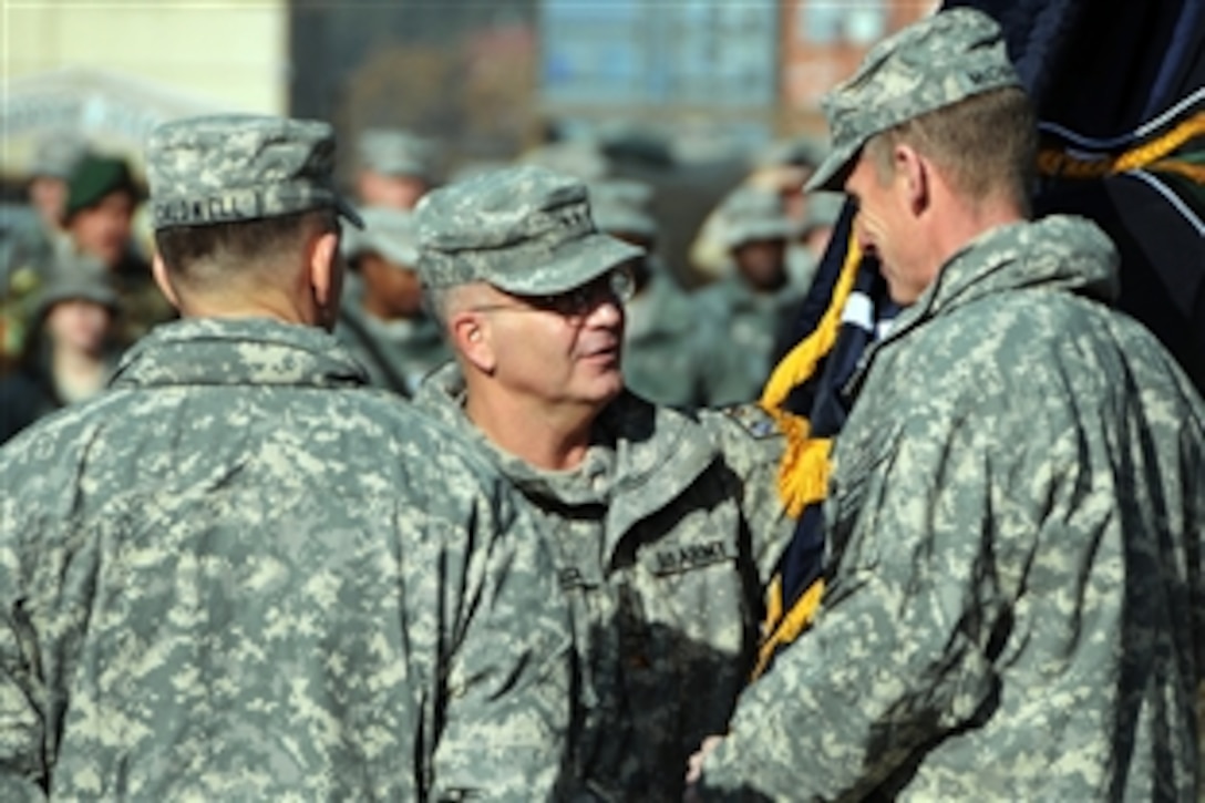 U.S. Army Maj. Gen. Richard P. Formica, center, hands the flag of command to Gen. Stanley McChrystal, right, the commander of U.S. Forces Afghanistan and International Security Assistance Force, during a ceremony marking the change of command prior to the official activation of NATO Training Mission Afghanistan on Camp Eggers in Kabul, Nov. 21, 2009.