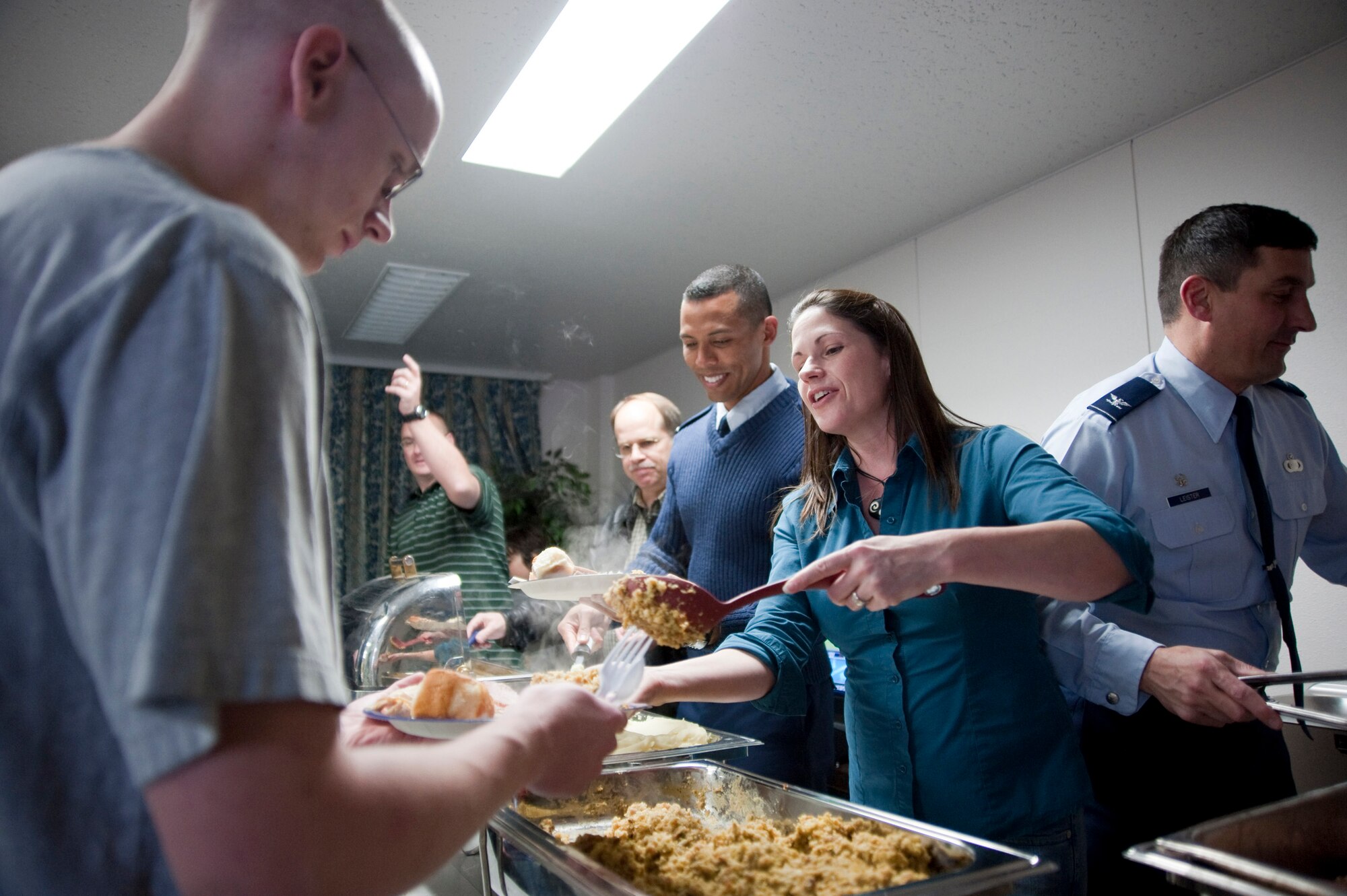 MISAWA AIR BASE, Japan -- Air Force Col. Barry Leister, 373rd Intelligence, Surveillance and Reconnaissance Group commander, and his wife, Alica, serve turkey, ham and stuffing to dormitory residents in the dayroom Nov. 23. The 373 ISRG holds this Annual Turkey Feed giving single and unaccompanied service members a taste of home. Colonel Leister said, "This is what it's all about, taking care of our military members." (U.S. Air Force photo/Staff Sgt. Samuel Morse)