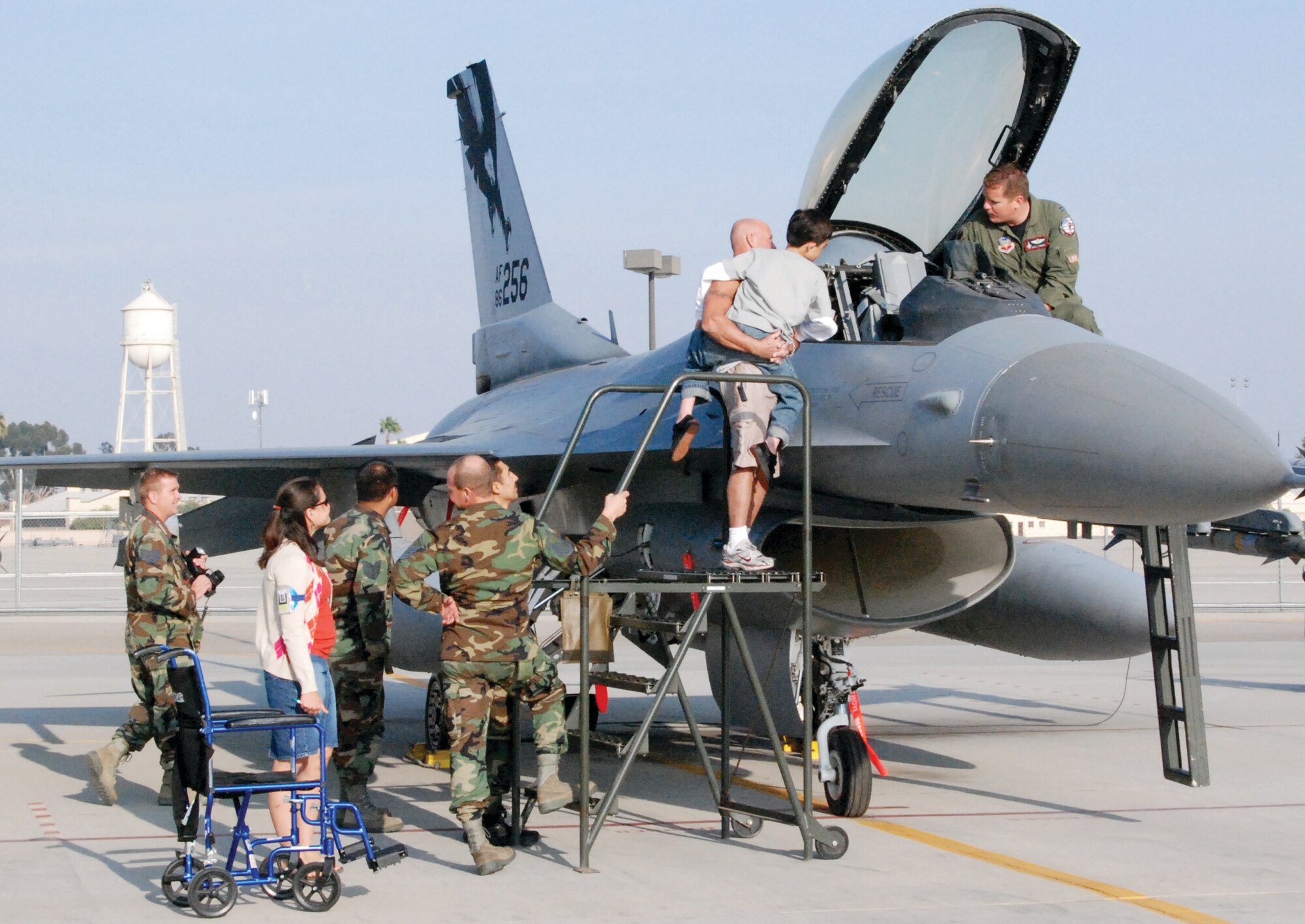 Peter Mundkowsky carries 12-year-old David Woodward up a set of stairs to view the cockpit of an F-16. David’s Nov. 7 visit to March ARB was a wish granted by the Make-A-Wish foundation and Team March units. (U.S. Air Force photo by Staff Sgt. Megan Crusher)
