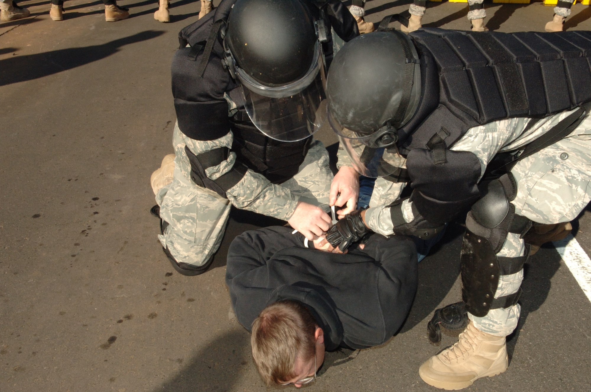 BUCKLEY AIR FORCE BASE, Colo. -- Members of the 460th Space Wing confrontation management team subdue a volunteer protestor Nov. 24. (U. S. Air Force photo by Tech. Sgt. Shirley Henderson)