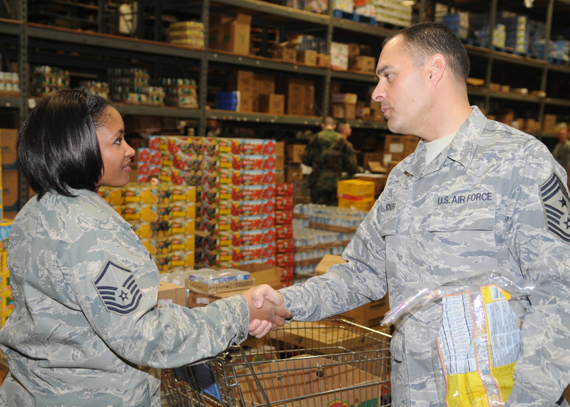 GOODFELLOW AIR FORCE BASE, Texas -- Chief Master Sgt. Frederick Ricker, 17th Training Wing command chief master sgt., greets Master Sgt. Kaleah Hodges, 17th Medical Operations Squadron, as she waits in line during Operation Warmheart, Nov. 24, 2009.  Chief Ricker went down the line greeting and thanking all of the volunteers. (U.S. Air Force photo/Airman Clayton Lenhardt)