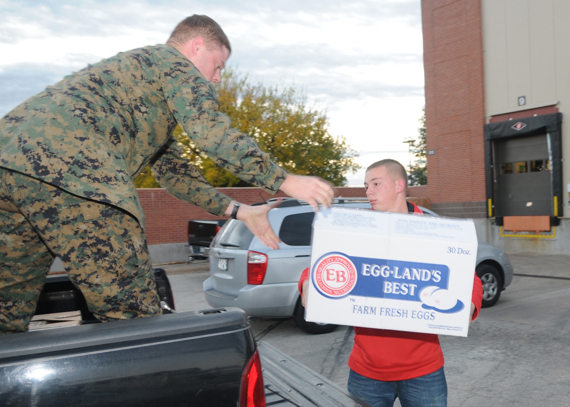 GOODFELLOW AIR FORCE BASE, Texas -- Airman 1st Class Brandon Flynn, 17th Security Forces Squadron, passes a Warmheart basket up to a Marine, Nov. 24, 2009. Operation Warmheart is a year-round program to assist servicemembers and their families by providing food, clothes, toys, and in some cases funds for those in need. The program is managed by the First Sergeants Council and supported by volunteers from the base and community. (U.S. Air Force photo/Airman Clayton Lenhardt)