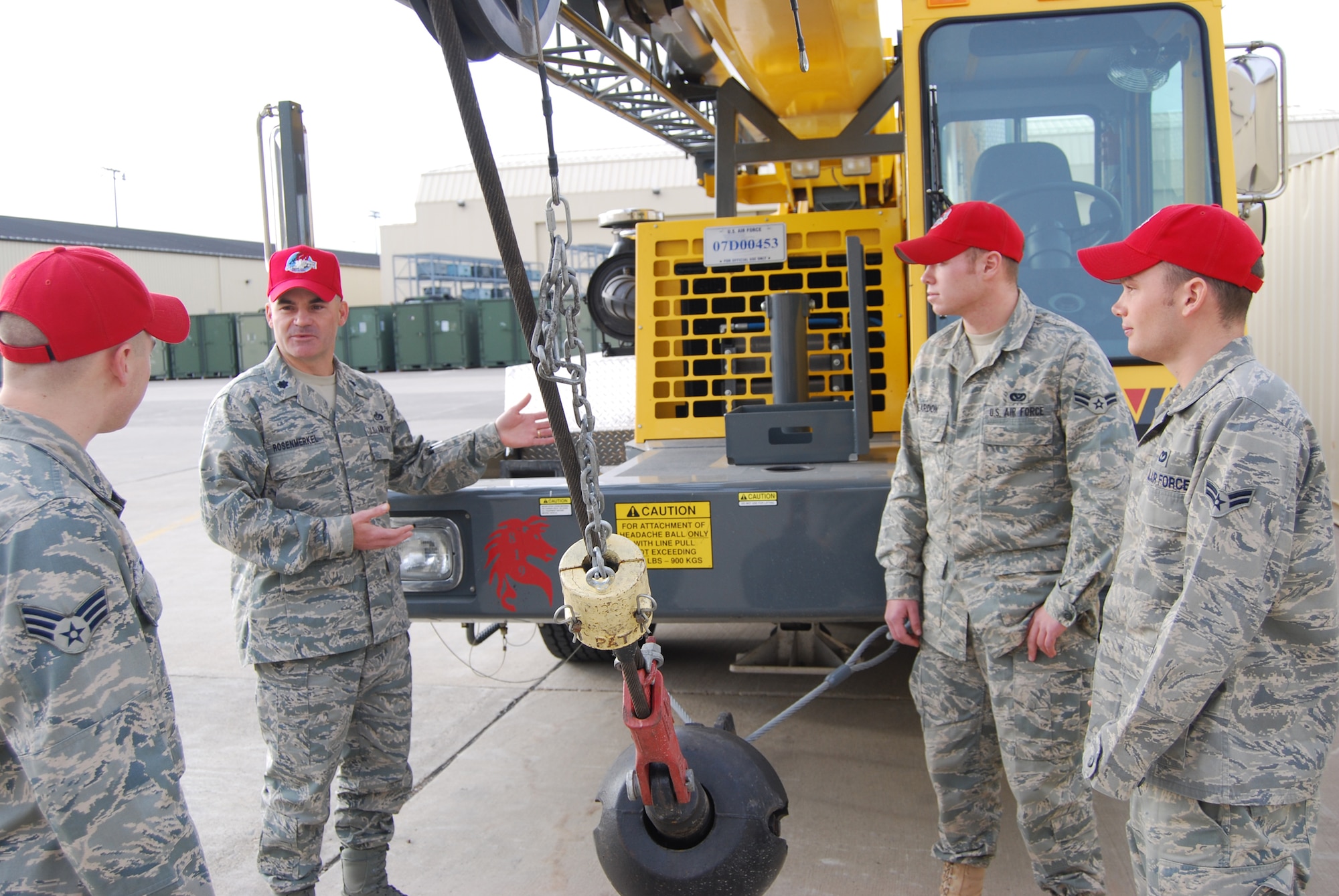 Lt. Col. Gregory Rosenmerkel, 819th RED HORSE Squadron commander, speaks with Airmen 1st Class Timothy Reardon and Steven Waisner, and Senior Airman Billy Crocker about the importance of the RED HORSE mission Nov.20 outside building 1460. RED HORSE members often use heavy machinery to accomplish their mission, such as the Grove 60-ton truck-mounted hydraulic crane, pictured here, that can lift up to 120,000 pounds. (U.S. Air Force photo/Airman 1st Class Kristina Overton)