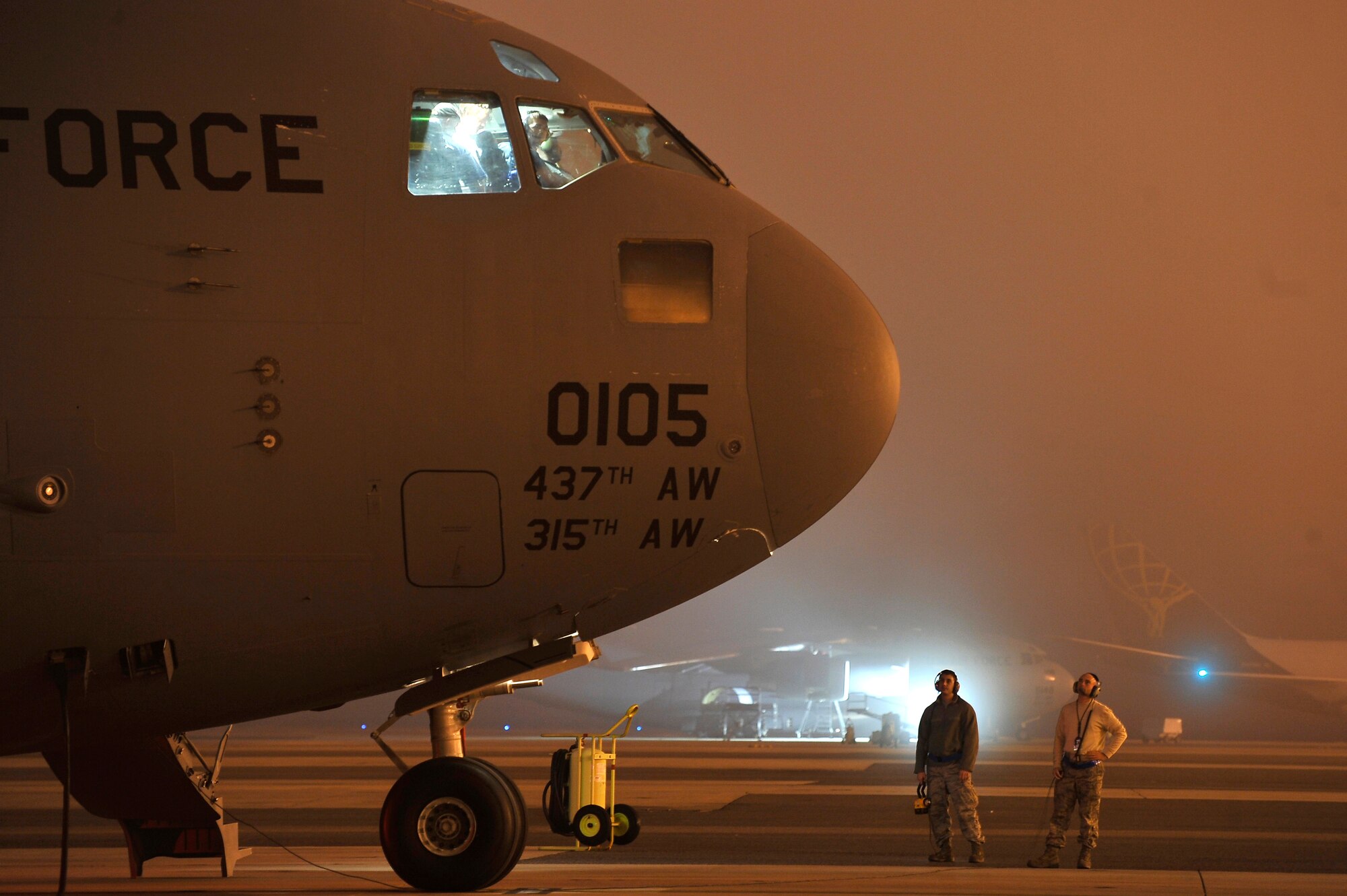 Airman 1st Class Vincent Ozzi, left, and Tech. Sgt. Kenneth Ervin stand by awaiting a maintenance engine run on the flightline here Nov. 19. The run up of the engine allows technicians to ensure all systems are fully functional before putting the aircraft into operational use. Both Airman Ozzi and Sergeant Ervin are electricians with the 437th Aircraft Maintenance Squadron. (U.S. Air Force photo/James Bowman)


