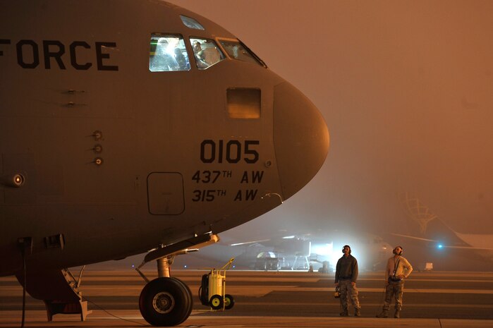 Airman 1st Class Vincent Ozzi, left, and Tech. Sgt. Kenneth Ervin stand by awaiting a maintenance engine run on the flightline here Nov. 19. The run up of the engine allows technicians to ensure all systems are fully functional before putting the aircraft into operational use. Both Airman Ozzi and Sergeant Ervin are electricians with the 437th Aircraft Maintenance Squadron. (U.S. Air Force photo/James Bowman)