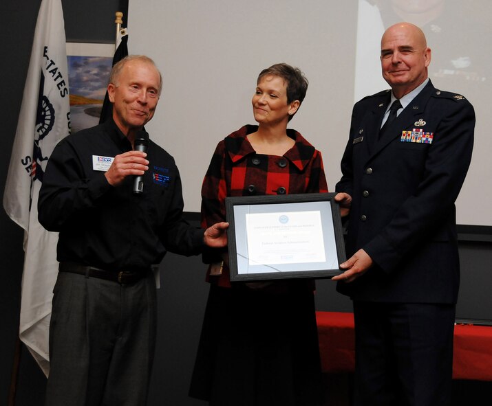 RENTON, Wash.,- Kathryn Vernon, center, Federal Regional Administrator with the Federal Aviation Administration here, accepts a Patriot Award  Nov. 10 from Washington Employer Support of Guard and Reserve Chairman Jim Shepherd (left) and Col. William Anholt, 446th Maintenance Group commander from McChord Air Force Base, Wash.  Ms Vernon was honored for her support of Air Force Reservist Staff Sgt. Nicole Celestine, 446th Airlift Wing at McChord, while Sergeant Celestine attended a 10-week technical training course at the Defense Information School, Fort Meade, Md. (Courtesy photo/Savoeun Preng)
