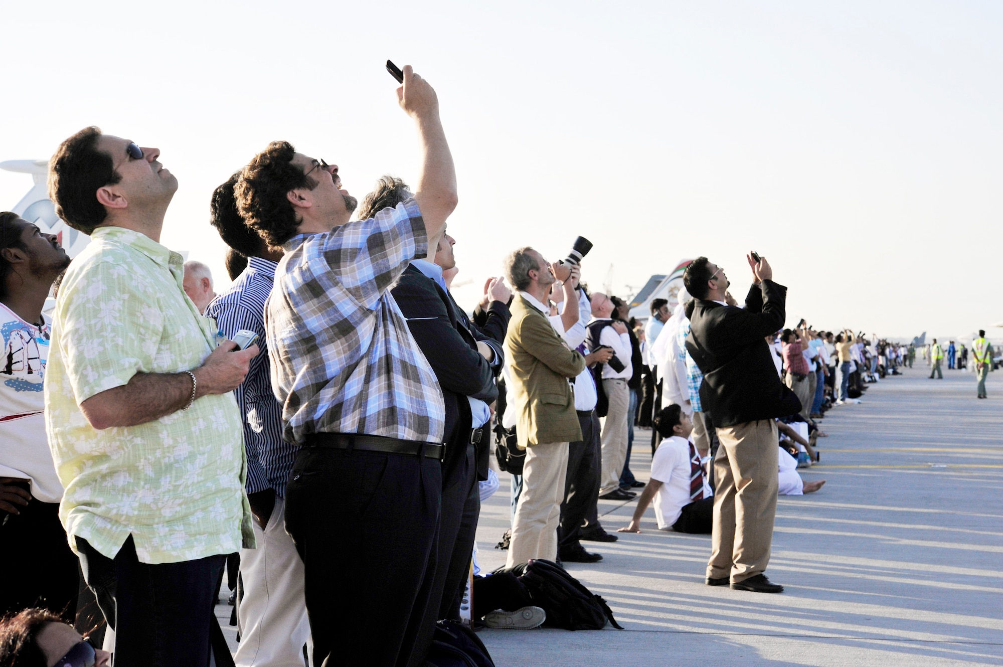 Air show patrons watch the F-22 Raptor fly an aerial demonstration Nov. 15, 2009 at the Dubai Air Show in the United Arab Emirates. The F-22 flew over the Dubai International Airport four times during the week of the air show. (U.S. Air Force photo/Tech. Sgt. Charles Larkin Sr.)