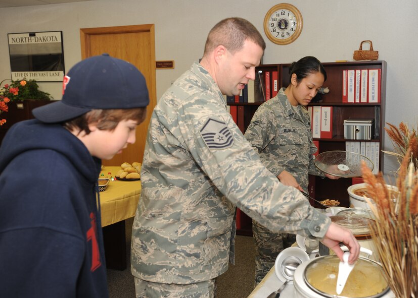 Master Sgt. Trevor R. Parsons, 319th Air Refueling Wing Manpower superintendent, opens a pot of soup at the Airman Family Readiness Center Nov. 23. This was the AFRC’s 3rd annual open house and soup supper celebration. (U.S. Air Force Photo by Staff Sgt. Suellyn F. Nuckolls)