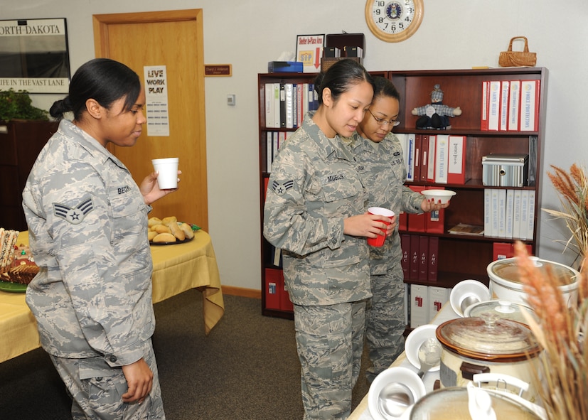 From left to right, Senior Airmen Amber Beckwith, Ingrid Mueller and Alexis McCray, 319th Force Support Squadron, try to decide which soup they will try at the Airman Family Readiness Center Nov. 23. This was the AFRC’s 3rd annual open house and soup supper celebration. (U.S. Air Force Photo by Staff Sgt. Suellyn F. Nuckolls)