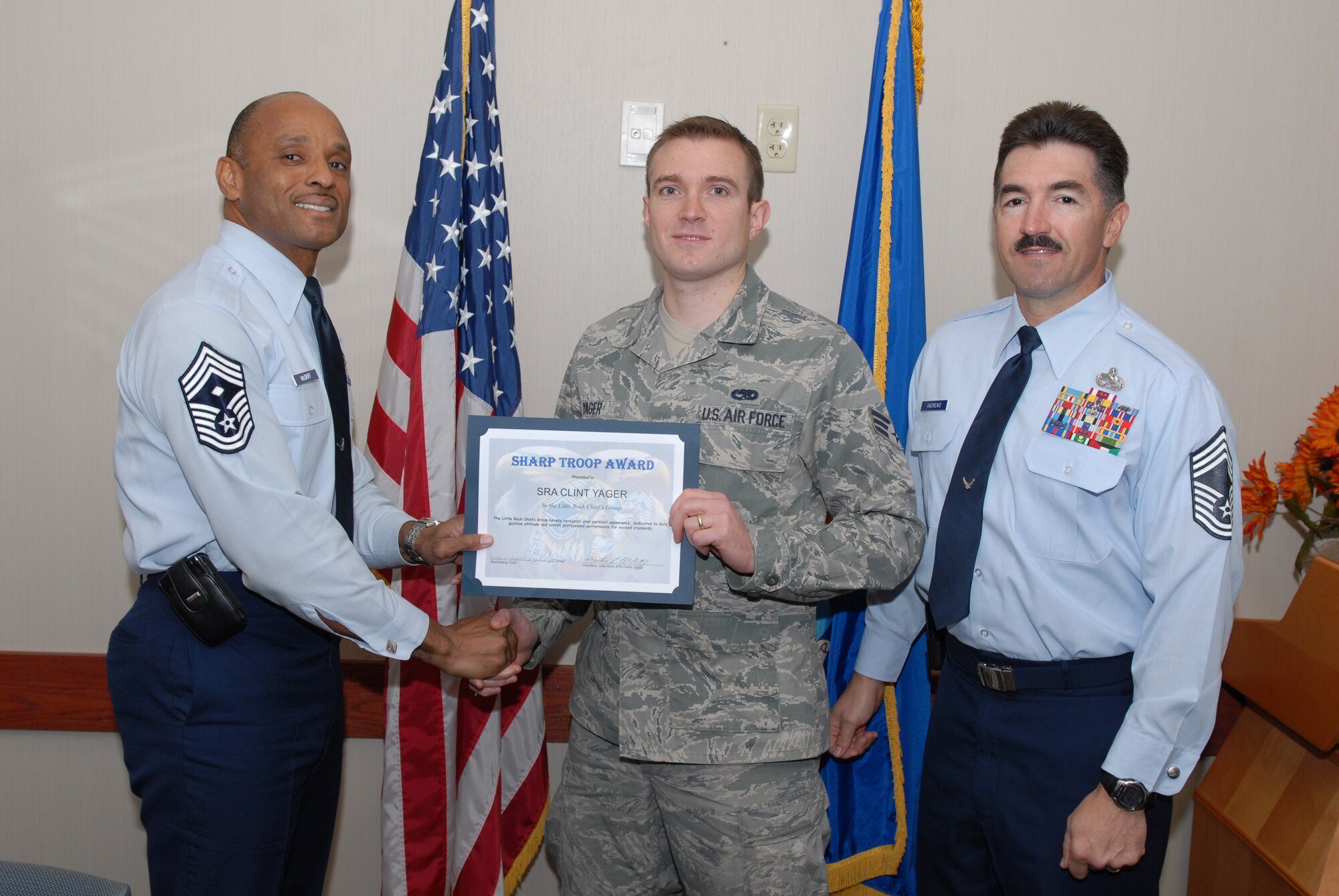 Chief Master Sgt. Frankie McGriff, 19th Equipment Maintenance Squadron first sergeant, and Chief Master Sgt. Devery Andrews, 19 Component Maintenance Squadron superintendent, present Senior Airman Clint Yager, 19 CMS electrical environmental systems journeyman, with a certificate Nov. 24 for his selection as the Little Rock Air Force Base Chief’s Group’s “Chief’s Sharp Troop” award. The Chief's Sharp Troop award is given to Airmen who set themselves apart through their outstanding Airmanship and accomplishments. (U.S. Air Force photo by Senior Airman Nathan Allen)
