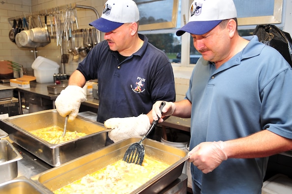 Chief Master Sgt. Dominick Tallarida, 911th Air Refueling Squadron chief, and Senior Master Sgt. Ken Jackson, 4th Equipment Maintenance Squadron munitions flight production section chief, scramble eggs during a Chief's Pancake Breakfast on Seymour Johnson Air Force Base, N.C., Nov. 20, 2009. Sergeant Jackson was recently selected for promotion to Chief Master Sergeant. During the breakfast base chiefs prepared food, served drinks and dished up food for Airmen passing through a buffet-style serving line. (U.S. Air Force photo/Airman 1st Class Rae Perry)