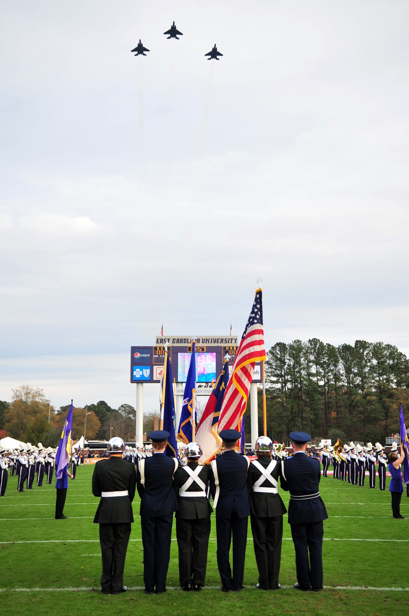 Members of the East Carolina University Air Force and Army Reserve Officer Training Corps present the colors as F-15E Strike Eagles flyover the ECU Dowdy-Ficklen Stadium, Greenville, N.C., Nov. 21, 2009. The F-15Es are based out of Seymour Johnson Air Force Base in Goldsboro, N.C. (U.S. Air Force photo/Airman 1st Class Rae Perry) 