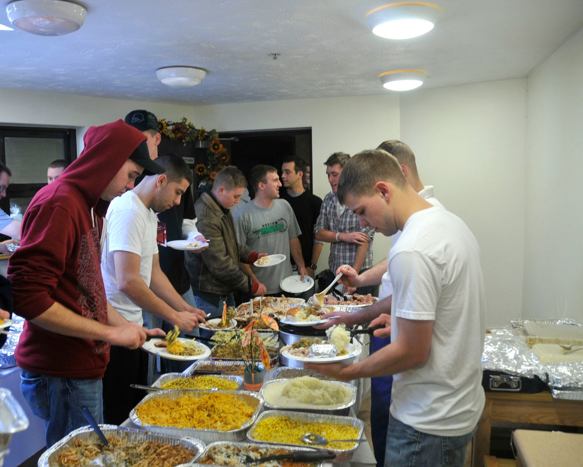 Residents from Dorm 917 helped themselves to a Thanksgiving feast organized by the 48th Maintenance Group first sergeants in the dormitory dayroom at RAF Lakenheath on Nov. 21. This was the inaugural dorm Thanksgiving dinner and will be a tradition from this point forward.  First sergeants, NCOs and families helped provide the food and drink. More than 100 Airmen were fed. (U.S. Air Force photo by Airman 1st Class Eboni Knox)