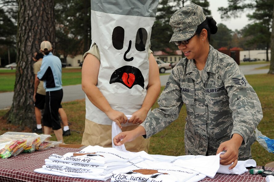 Staff Sgt. Celeste Spears, 4th Medical Group non-commissioned officer in charge of nutritional medicine, folds t-shirts on the prize table during the annual 5K and 10K Turkey Trot on Seymour Johnson Air Force Base, N.C., Nov. 20, 2009. The fitness center and health and wellness center host the event to encourage members to stop smoking for one day as well as bolstering their physical fitness levels and overall wellness. (U.S. Air Force photo/Senior Airman Courtney Richardson)