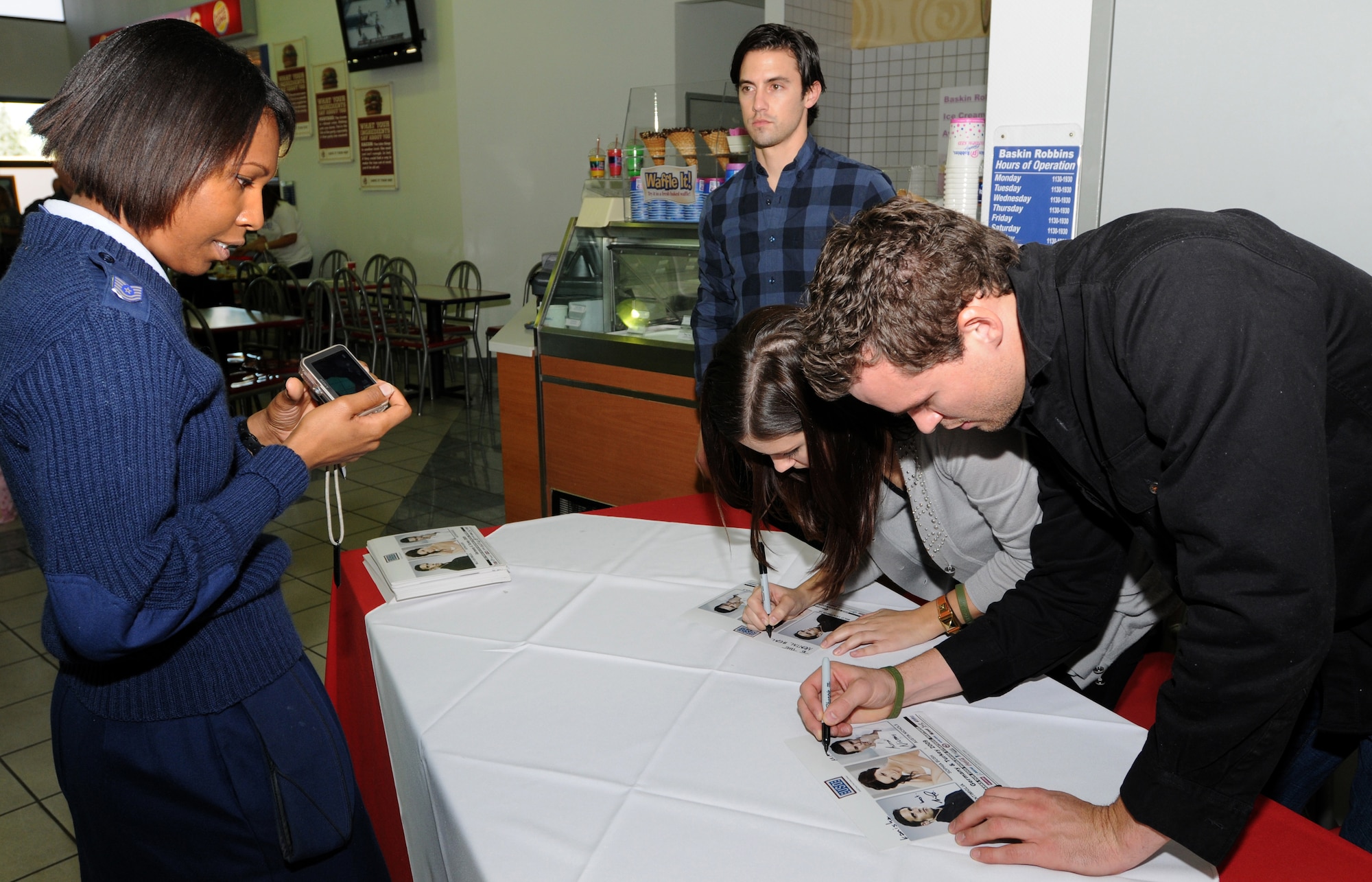 Tech. Sgt. Kanisha Carson gets an autograph from (left to right) Milo Ventimiglia, from the television show Heroes, and Sophia Bush and Austin Nichols, both from the television show One Tree Hill, Monday, Nov. 23, 2009 at Incirlik’s BX food court.  The three TV stars are visiting Incirlik as part of the celebrity handshake tour sponsored by United Service Organizations.  (U.S. Air Force photo/Senior Airman Ashley Wood)  