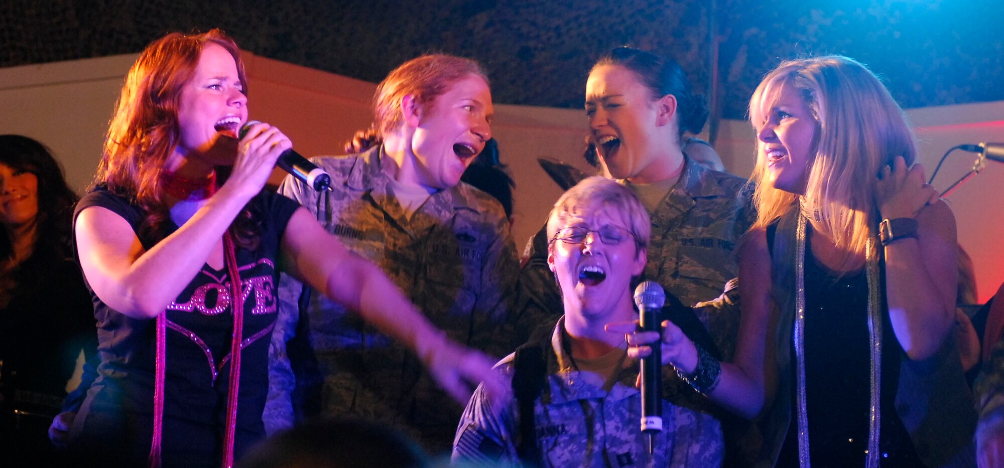 BAGRAM AIRFIELD, Afghanistan -- Tech. Sgt. Amanda Burns (left) and Senior Airman Kayla Bilger (right) sing onstage with members of The Lt. Dan Band, 23 Nov. 2009. Sergeant Burns,
a Falmouth, Ken., native deployed from the U.S. Air Force Academy won a pair of round trip tickets to anywhere in the States. Airman Bilger is from Hartland, Mich., and is deployed from Geilenkirchen Air Base
Squadron, Germany. (U.S. Air Force photo/ Senior Airman Susan Tracy)