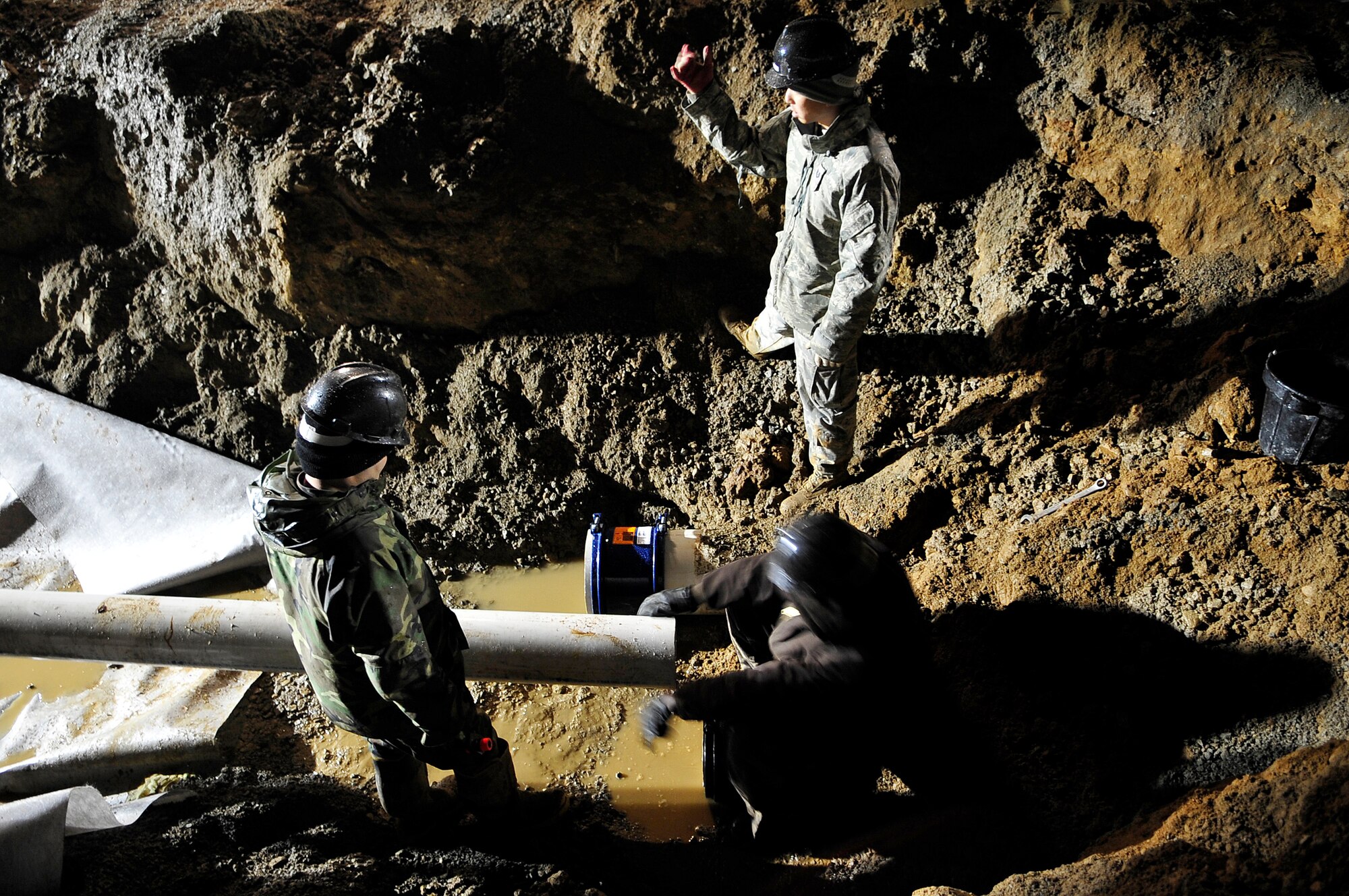 Airmen from the 51st Civil Engineer Squadron replace a section of an eight-inch water main that ruptured at Osan Air Base, Republic of Korea, Nov. 20. The pipe broke due to an underground slippage of concrete that was used to cover a pre-existing benjo ditch near the pipes. Airmen and civilians from agencies across Osan worked together for more than 24 hours to repair the broken eight and 12 inch water mains. (U.S. Air Force photo/Staff Sgt. Brian Ferguson)

