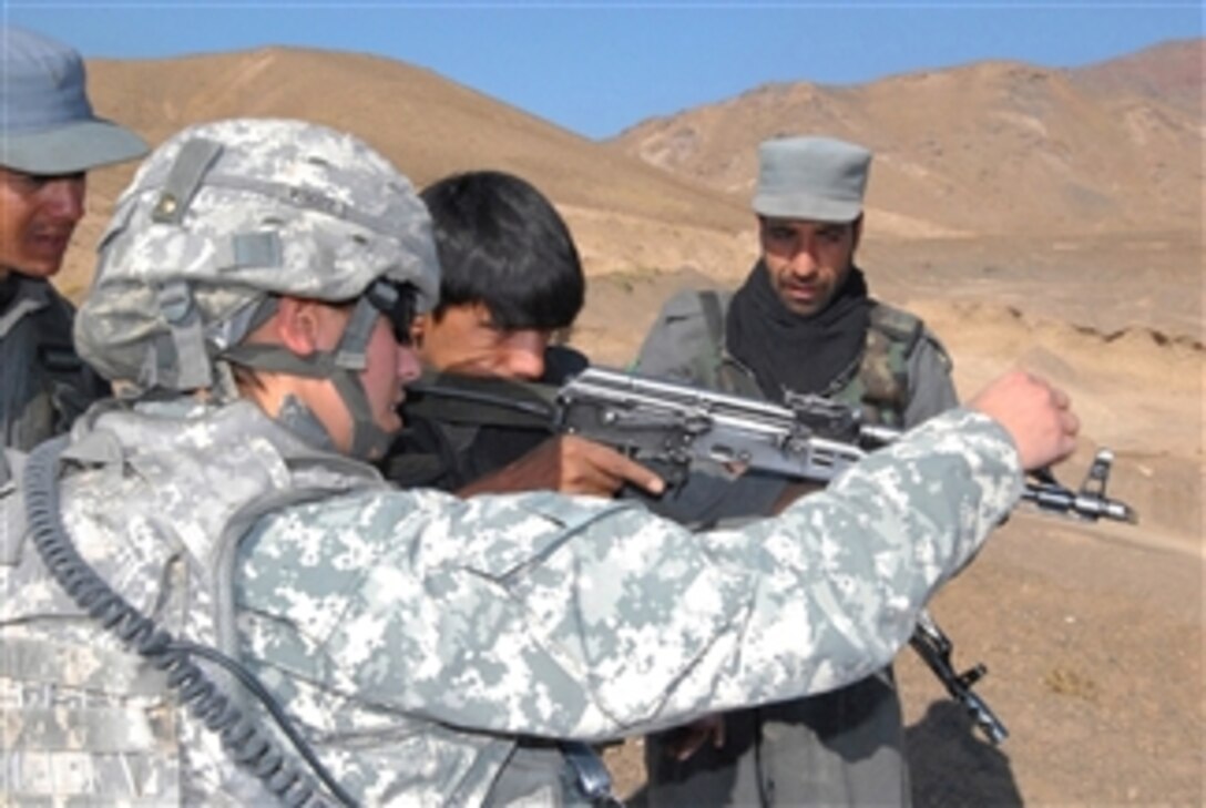 U.S. Army Cpl. Mona Paul, 410th Military Police Company, Task Force Cyclone, gives Afghan Policemen sight picture tips before heading to the firing range in Jabal Saraj district, Parwan province, Afghanistan, on Nov. 11, 2009.  The live range exercise was the last part of immersion training before certification by the military police members.  Paul has worked with the group since July implementing new police immersion training standards.  