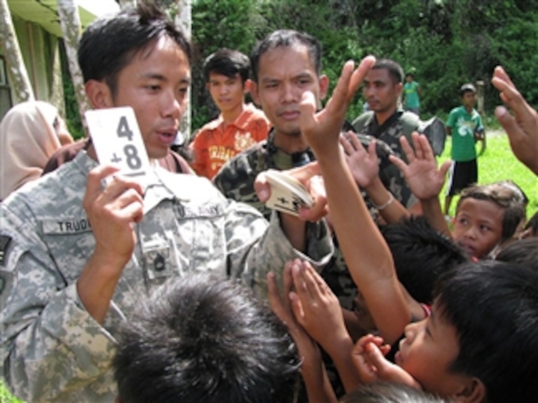 U.S. Army Sgt. 1st Class Michael Truoy and Armed Forces of the Philippines Capt. Ramio Angcap display flashcards to children during a medical civic action project in the Languyan municipality of the Tawi Tawi province of the Philippines on Nov. 21, 2009.  Truoy is from Joint Special Operations Task Force-Philippines and is a member of Civil Affairs Team 731.  The project, a first in the area, treated more than 400 patients for minor ailments and gave out free supplies, including four wheelchairs.  