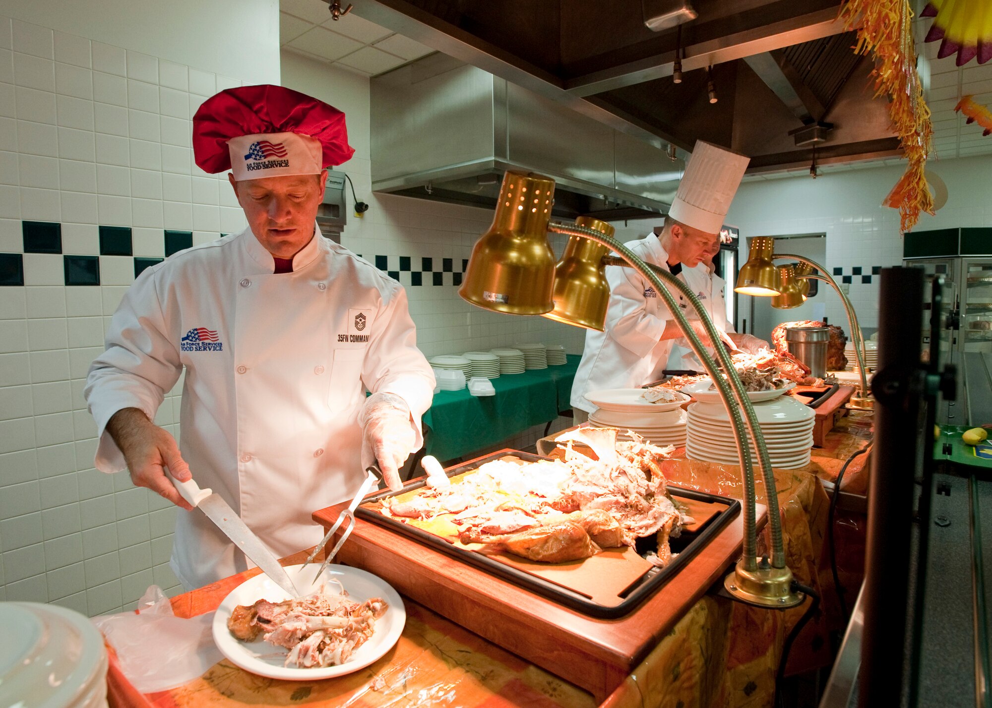 MISAWA AIR BASE, Japan -- Chief Master Sgt. Russell Hastings, 35th Fighter Wing command chief master sergeant, prepares servings of turkey at the Grissom Dining Facility on Thanksgiving, Nov. 26. Wing leadership served 350 service members. (U.S. Air Force photo/Staff Sgt. Samuel Morse)