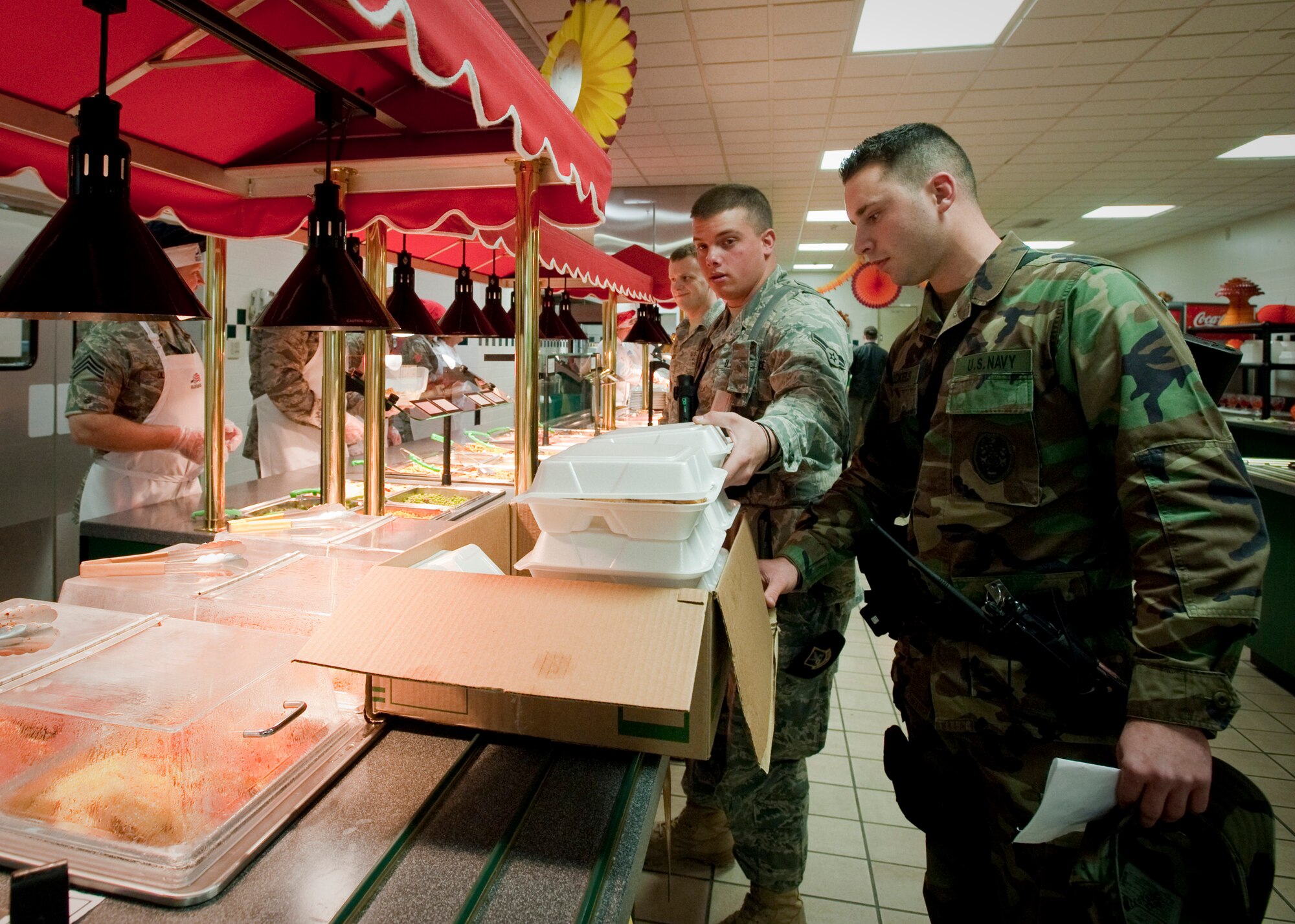 MISAWA AIR BASE, Japan -- While at the Grissom Dining Facility, Airman 1st Class David Cook, 35th Security Forces Squadron, and Seaman Caleb Nuckels, Naval Air Facility Security Forces, fill a box with meals for their fellow Airmen and Sailors who were on duty during Thanksgiving, Nov. 26. (U.S. Air Force photo/Staff Sgt. Samuel Morse)