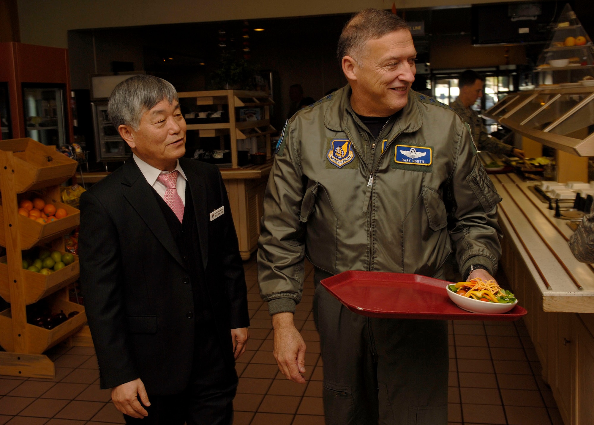 Choe Tong Yong, O’Malley Dining Facility manager, and Gen. Gary North, Pacific Air Forces commander, walk through the facility at Kunsan Air Base, Republic of Korea before they join 8th Fighter Wing Airmen for lunch Nov. 23. General North is sponsoring four civic leaders from the Air Force Civilian Advisory Council as they tour Kunsan and Osan Air Bases, ROK, Nov. 21-26. The purpose of the trip is for General North to celebrate Thanksgiving with the Airmen while the civic leaders gain a better understanding of life for Airmen assigned to the ROK. (U.S. Air Force photo/Tech. Sgt. Jerome S. Tayborn)  