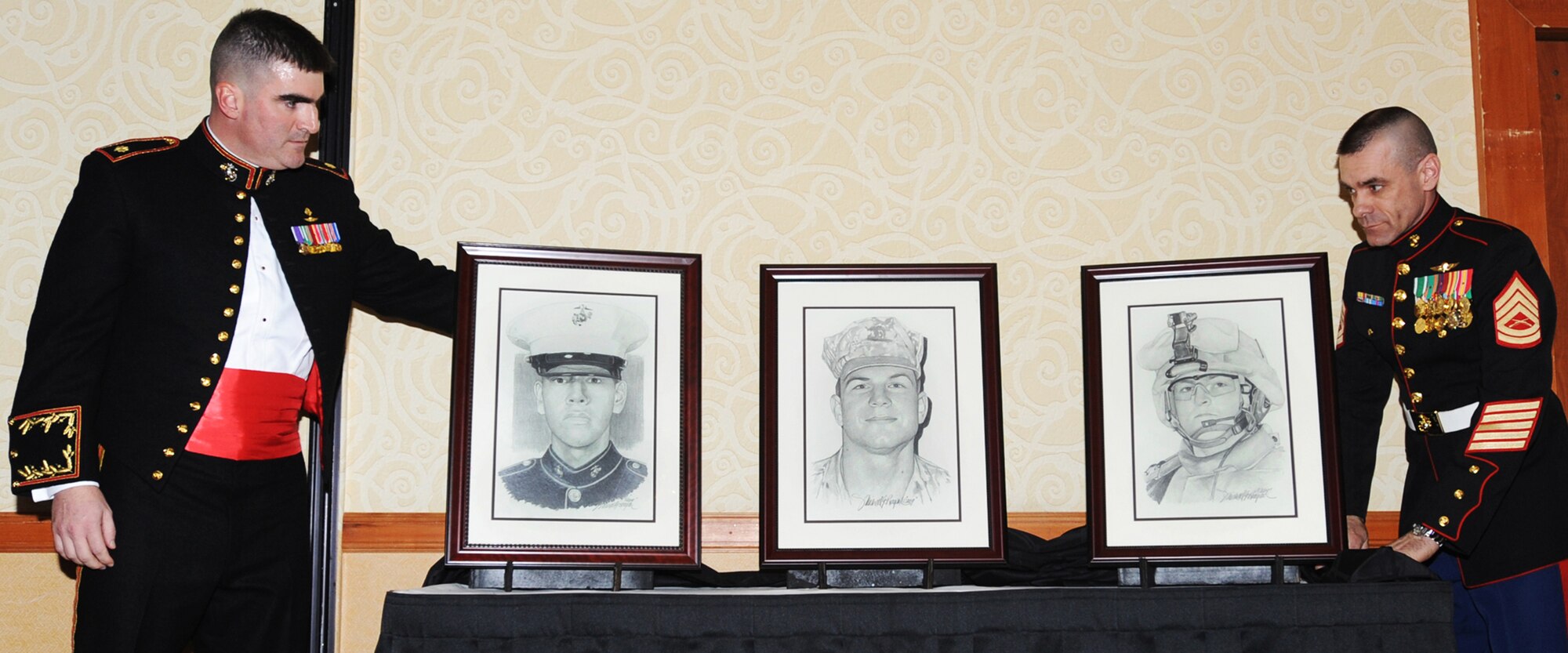 ANCHORAGE, Alaska -- Maj. William Allen and Gunnery Sgt. Bradley Miller from D Company (-) Anti-Terrorism Battalion 4th Marine Division present renderings of fallen Alaskan Marines to their family members during the United States Marine Corps 234th Birthday Ball Nov. 21, 2009 at the downtown Anchorage Hilton. The renderings were drawn by Michael Reagan, a portrait artist who offers free portraits to families of fallen servicemembers. (U.S. Air Force photo/Senior Airman Laura Turner)