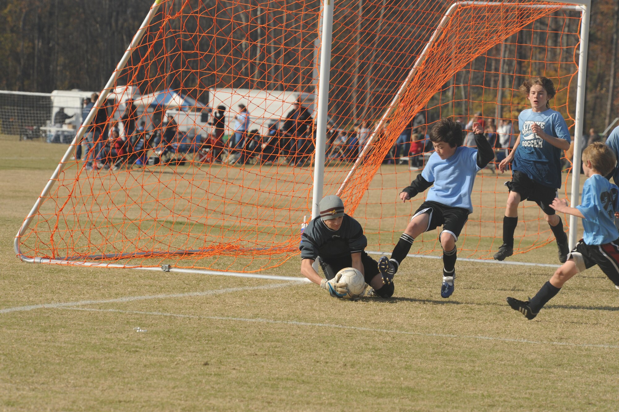 Jordan Bailey, Strike Eagle FC goalie, falls on the ball and stops an offensive attack by Graham Phoenix player during a two-day 2009 State Wide Athletic Counsel Tournament held at the Rocky Mount Sports Complex, in Rocky Mount, N.C., Nov. 21-22, 2009.  Graham Phoenix beat Strike Eagle FC, 3-0. More than 30 boys and girls, ages, 12 to 15 years old, comprised the Strike Eagle FC teams from Seymour Johnson Air Force Base and the Goldsboro YMCA youth programs. (U.S. Air Force photo/Tech. Sgt. Lesley Waters)