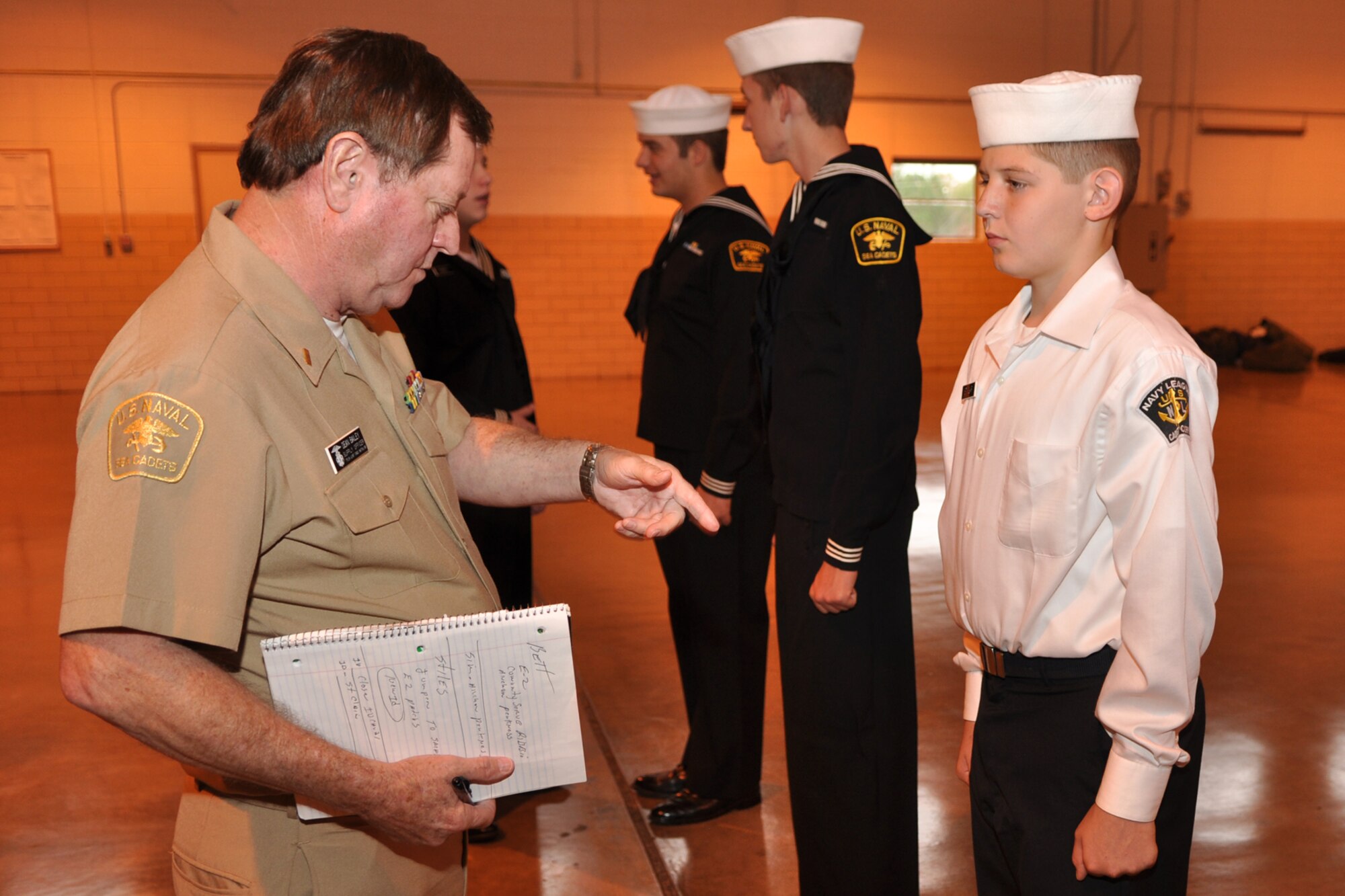 Ensign Dean Bailey, supply officer, U.S. Naval Sea Cadet Corps, Tyler Joint Force Battalion, inspects the dress uniform of U.S. Navy League Cadet Corps cadet Paul St. Clair during the drill weekend for the Tyler Joint Force Battalion at the US Army National Guard Armory in Tyler, Texas, November 21, 2009. The TJFB cadets are preparing for a U.S. Flag Retirement Ceremony at the American Legion Post 12 in Tyler. Early next year, the cadets plan to retire more than 100 flags that have been collected by various organizations and individuals. The ceremony is used to promote American Heritage and provide a Community service by honorably disposing of worn United States Flags. (Courtesy photo)