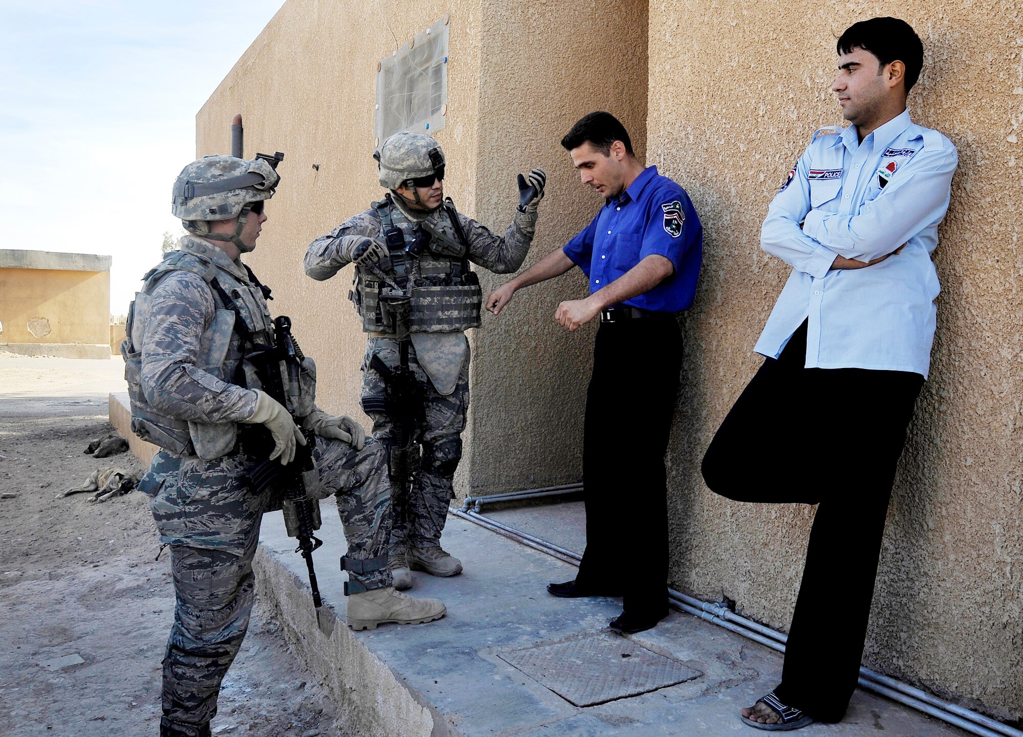 Staff Sgts. Zachary Hoover and Julis Matos speak with Iraqi police outside one of their local stations, Nov. 15, 2009, at Baghdad, Iraq. Sergeants Hoover and Mato are 732nd Expeditionary Security Forces Squadron Det. 2 fire team members deployed to Baghdad, Iraq. (U.S. Air Force photo/Staff Sgt. Angelita Lawrence)