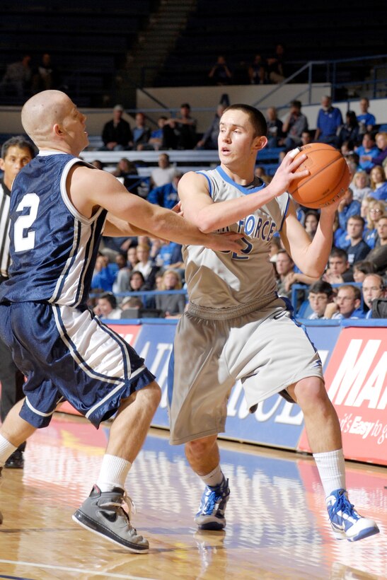 U.S. Air Force Academy, CO- Shawn Hempsey, a sophomore guard from Encinitas, CA looks to pass the ball past Dickinson State's Brian Lebsock  during the Reggie Minton Air Force Classic at Clune Arena Nov 20. The Falcons won 95-77, but finished the tournament in 2nd place after a 70-46 loss to Northern Colorado in the championship game.   Air Force Photo/J. Rachel Spencer