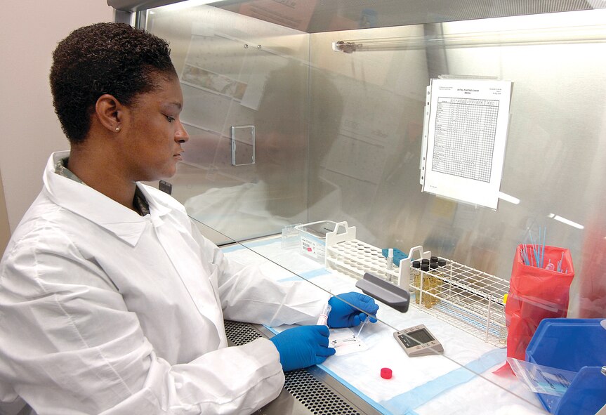 Tech. Sgt. Avri McKnight runs rapid flu tests in a hooded environment that uses forced air to keep airborne particles in the testing environment, protecting the Microbiology technician. (Air Force photo by Margo Wright) 