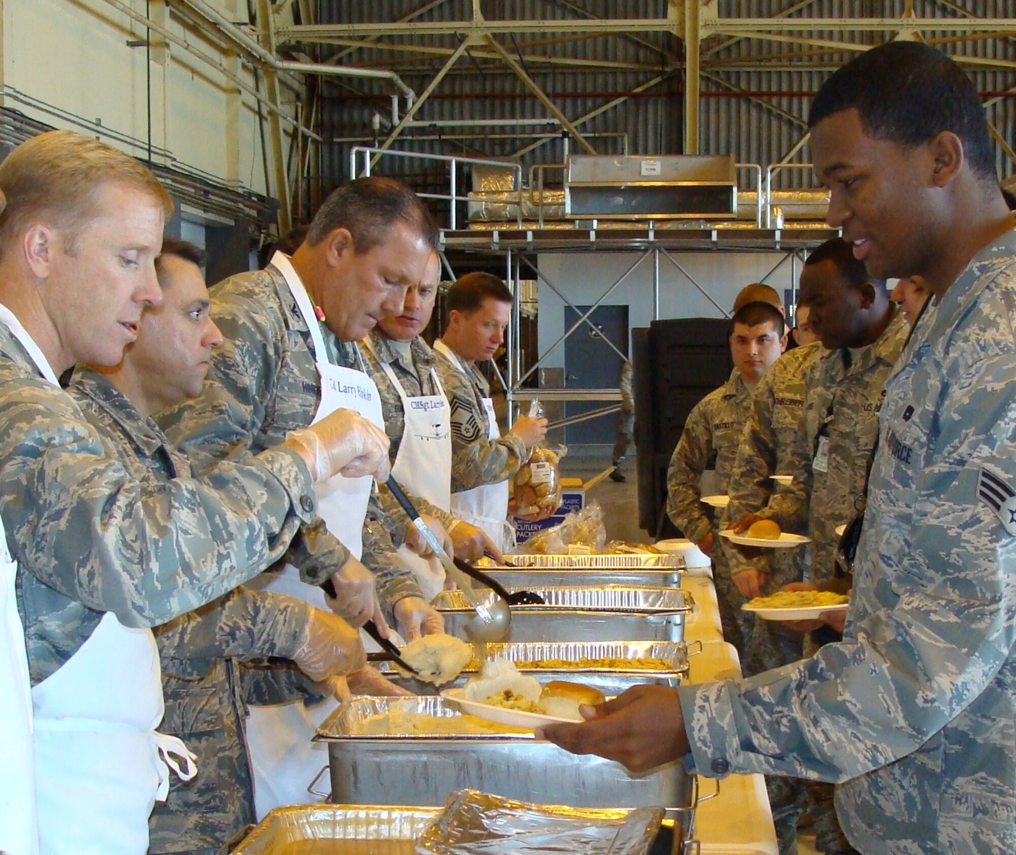 The 552nd Maintenance Group leadership served more than 1,200 meals to hungry Airmen and their families over the course of three shifts. The annual 552nd MXG Turkey Feast is just one of the simple ways for the leadership to give back to their troops for the hard work they have done over the past year. (Air Force photo by 1st Lt. Samuel Lee) 
