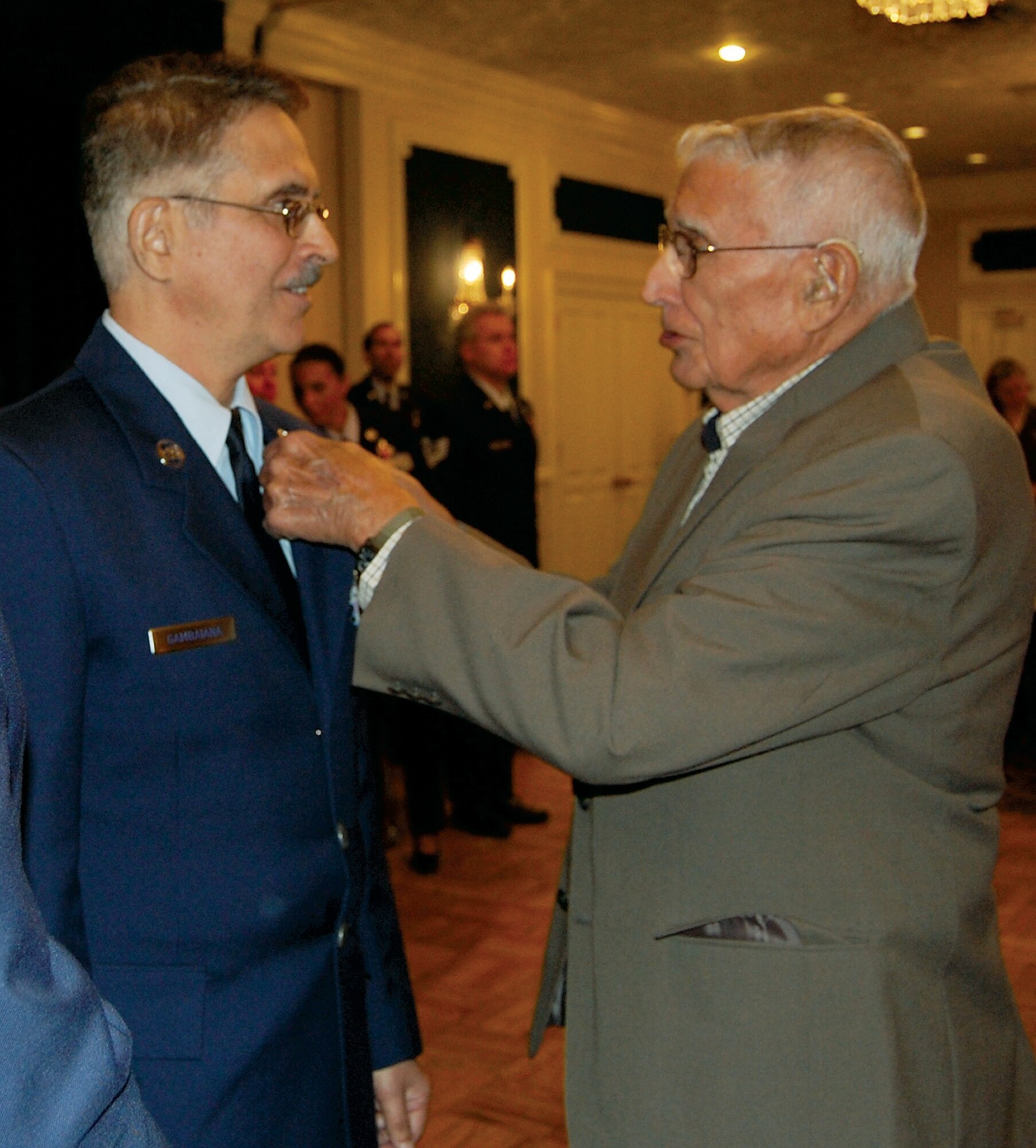 Chief Master Sgt. Steven J. Gambaiana receives a retirement pin from his father, a World War II veteran, during the 710th Medical Squadron mass retirement ceremony Oct. 3. The 710th MDS hosted the mass retirement ceremony prior to the squadron's deactivation. The 710th MDS is a geographically separated unit of the 442nd Fighter Wing, Whiteman Air Force Base, Mo. (U.S. Air Force photo by Debbie Aragon)
