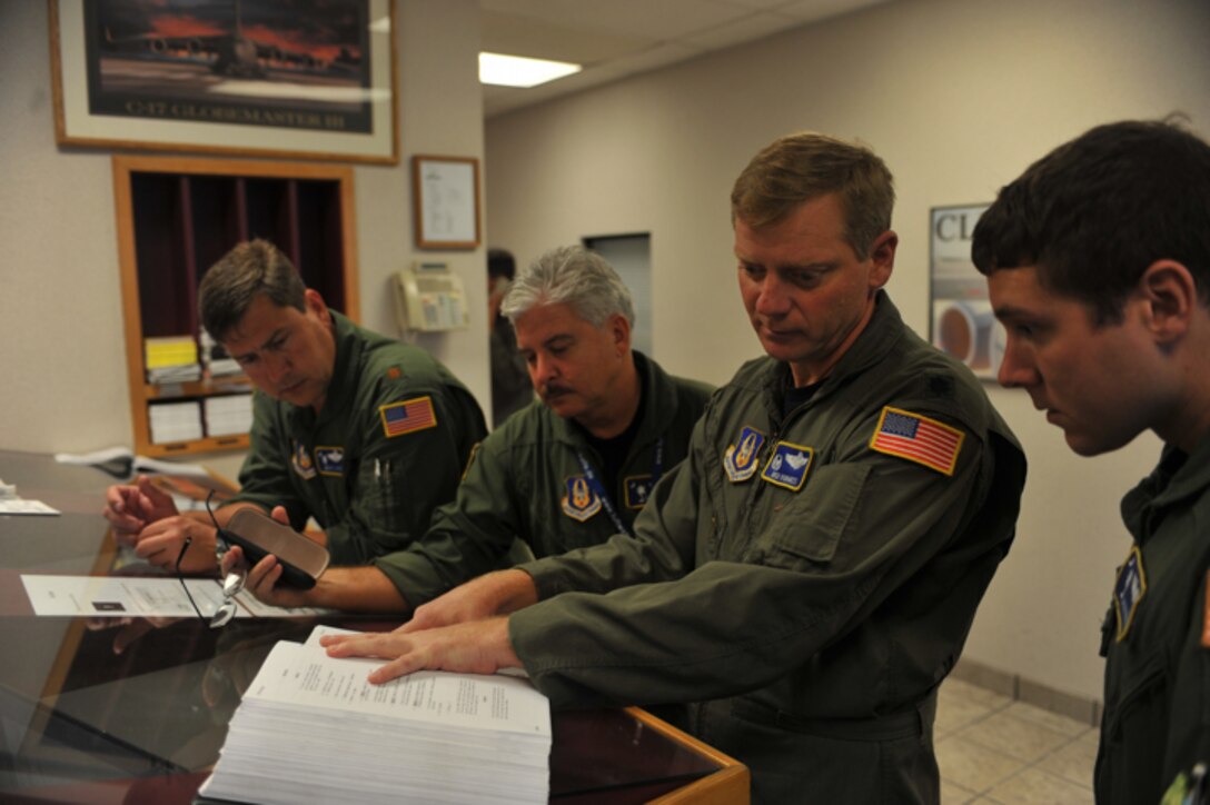 U.S. Air Force pilot Lt. Col. Ben Vorhees (center) goes over the dash one with 1st Lt. Jake Robbins (right) before a training mission at Charleston AFB, S.C. on Nov. 23, 2009.Lt. Col. Vorhees and 1st Lt. Robbins are assigned to the 300th Airlift Squadron, Charleston AFB, S.C. (U.S. Air Force photo/Staff Sgt. Quinton Russ)