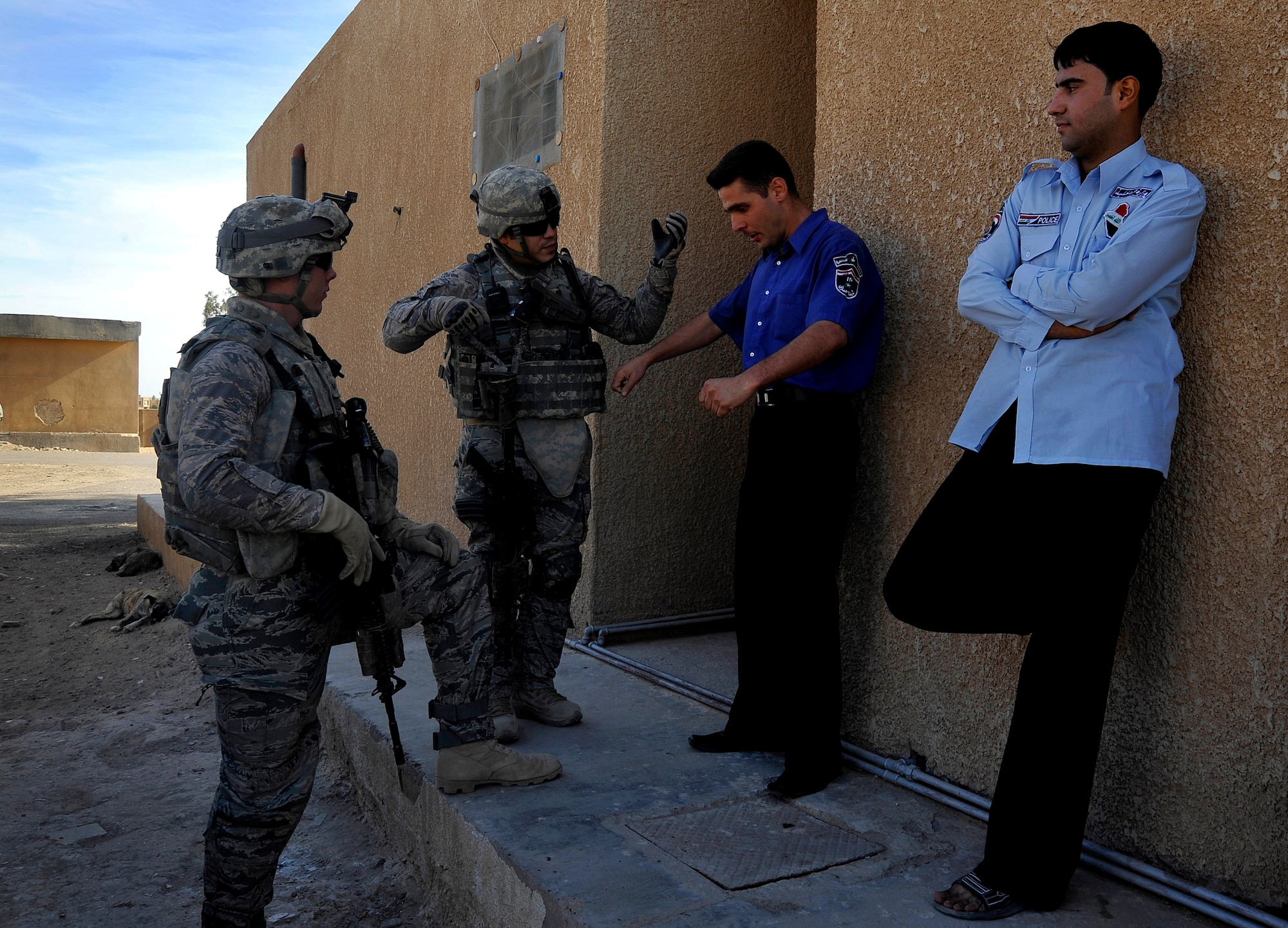 U.S. Air Force Staff Sgts. Zachary Hoover and Julis Matos, 732nd Expeditionary Security Forces Squadron Det. 2 fire team members, deployed to Baghdad, Iraq, speak with Iraqi police outside one of their local stations, Nov. 15, 2009. (U.S. Air Force photo/Staff Sgt. Angelita Lawrence)