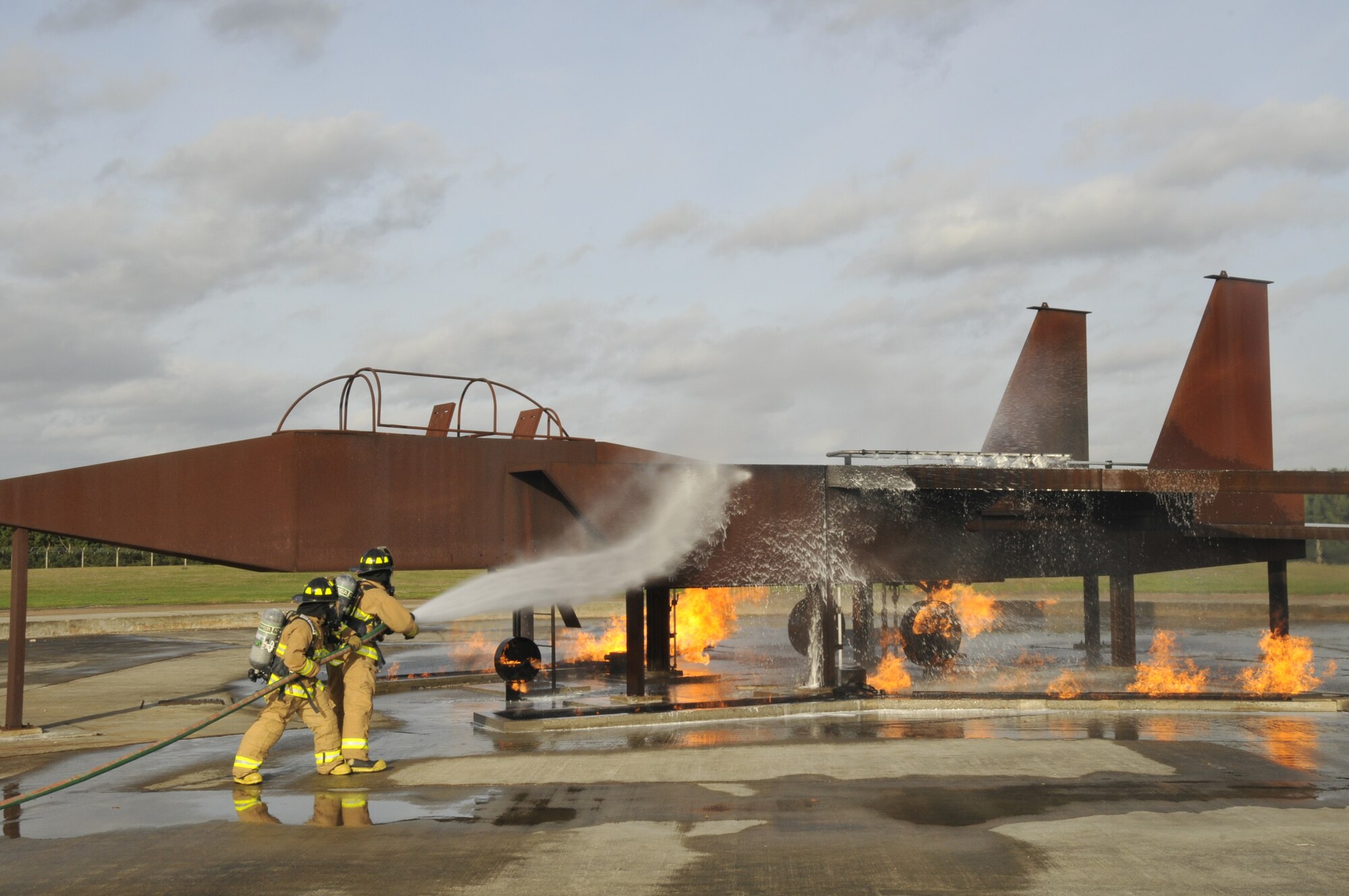 Staff Sgts. Robert Payne, 48th Civil Engineer Squadron Fire Protection crew chief, and Jonathan Peaden, 48th CES fire fighter, fight a controlled aircraft fire during an emergency management exercise on RAF Lakenheath, England, Nov.19. The EME included all base response teams. The teams were assessed by the 48th Fighter Wing Vice Commander Inspection team on compatibility and effectiveness. (U.S. Air Force photo by Airman 1st Class Eboni Knox)