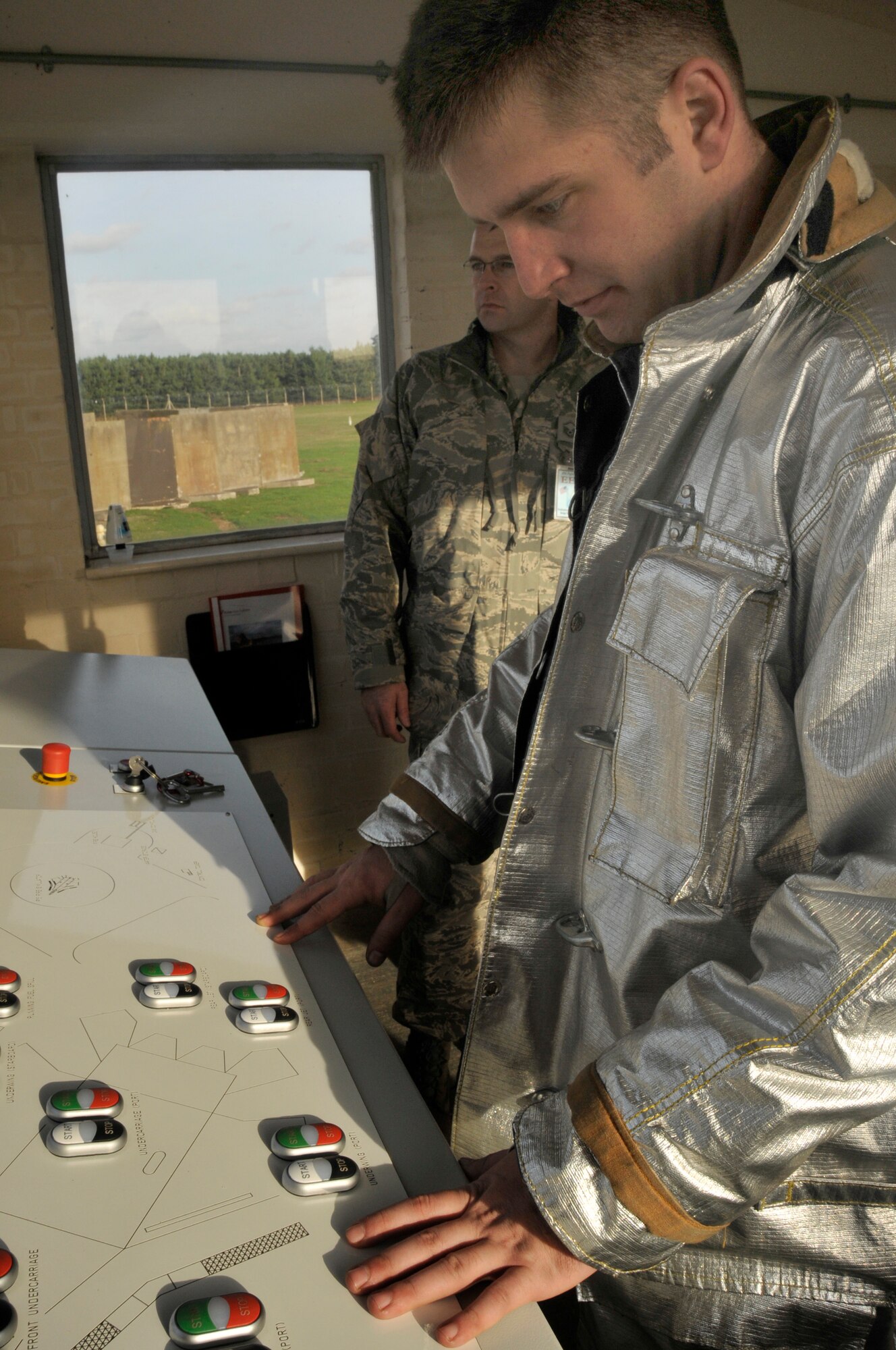 Staff Sgt. Henry Stratton receives training in the control room for the live fire trainer aircraft during an emergency management exercise on RAF Lakenheath, England, Nov. 19.  The EME, assessed the base reponse teams on a controlled aircraft fire used to train and evaluate  fire fighters. (U.S. Air Force photo by Airman 1st Class Eboni Knox)