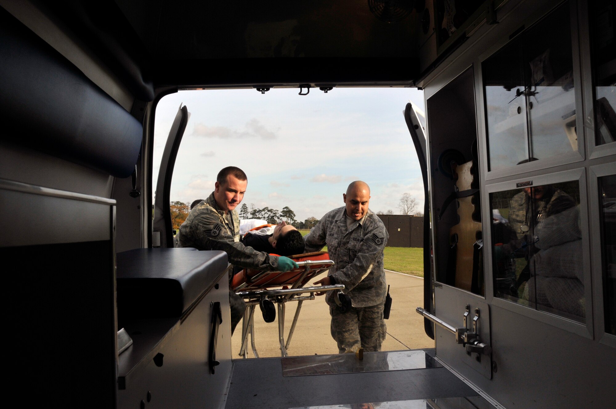 Staff Sgts. Michael McNamara and Jose Lucio, 48th Medical Group medical technicians, lift a simulated patient into an ambulance during an emergency management exercise on RAF Lakenheath, England, Nov. 19.  They were evaluated on their response time and life saving techniques/procedures during a 48th Fighter Wing Vice Commander Inspection. (U.S. Air Force photo by Airman 1st Class Eboni Knox)