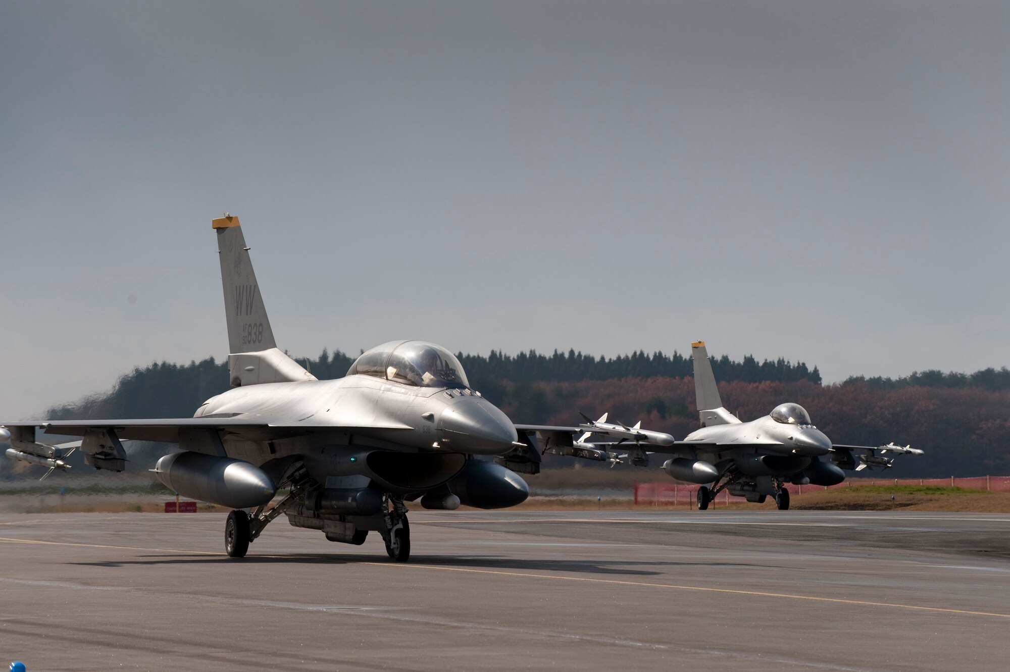 MISAWA AIR BASE, Japan -- A dual-seat F-16 Fighting Falcon taxis in front of its single-seat counterpart Nov. 20. Two Japan Air Self-Defense Force generals were offered a unique opportunity to get a firsthand perspective of the 35th Fighter Wing's mission from the backseat of an F-16. (U.S. Air Force photo/Staff Sgt. Samuel Morse)