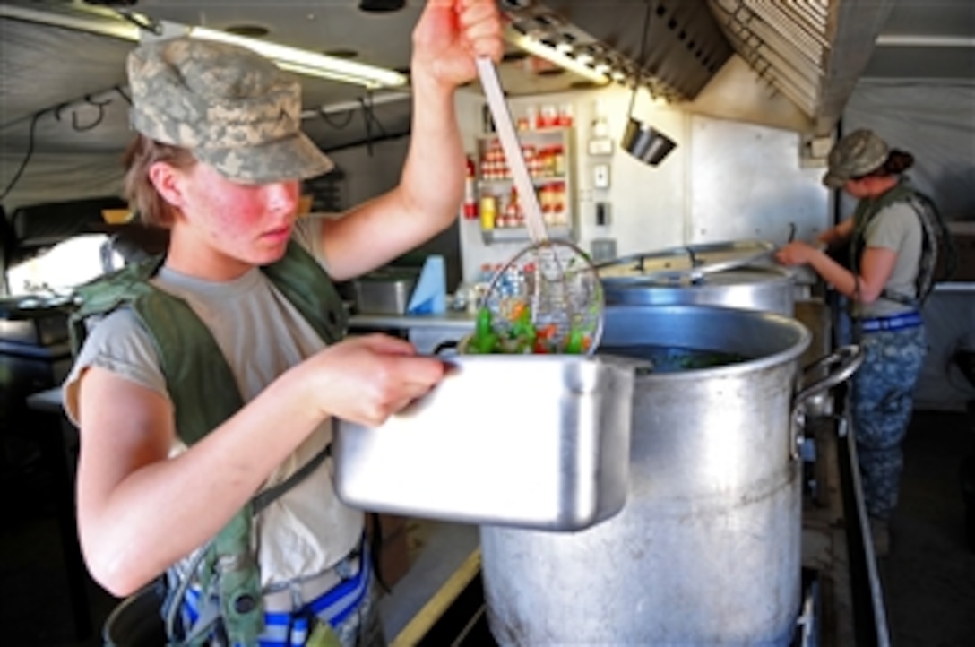 U.S. Army Pvts. Renee Harris and Paige Atkinson, both with the 64th Brigade Support Battalion, 3rd Brigade Combat Team, 4th Infantry Division, prepare food in a field kitchen at Fort Irwin, Calif., during National Training Center 2010-02 training on Nov. 16, 2009.  The training, held 10 times a year, provides realistic joint and combined arms training in interagency, intergovernmental and multinational venues to prepare brigade combat teams for combat.  