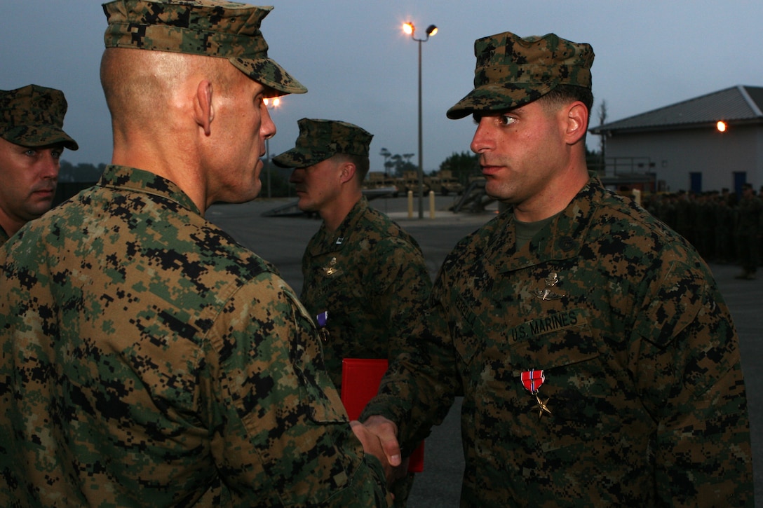 Lt. Col Peter D. Huntley, the commanding officer of 2d Marine Special Operations Battalion, U.S. Marine Corps Forces, Special Operations Command presents Gunnery Sgt. Michael Perella with the Bronze Star Medal with combat distinguishing device Nov. 25, 2009 behind the 2d MSOB headquarters building on Stone Bay. Perella received the Bronze Star Medal with combat distinguishing device for actions in the Helmand, Province, Afghanistan in October of 2007.