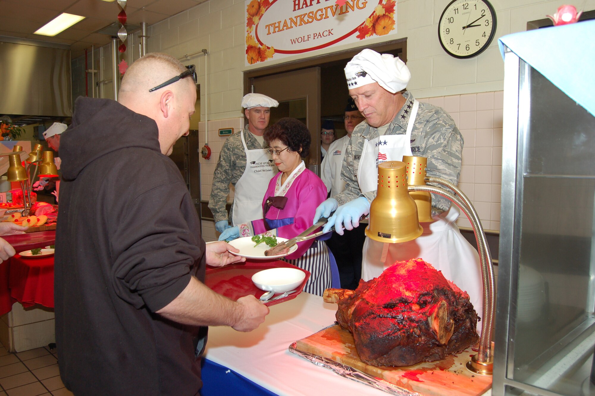 KUNSAN AIR BASE, Republic of Korea—Tech Sgt. Richard Brown of the 8th Security Forces Squadron receives his Thanksgiving dinner from Gen. Gary North, Pacific Air Forces commander, at the O’Malley Dining Facility here 26 November.  Gen. North visited Kunsan with senior leaders from PACAF and the 7th Air Force and members of the PACAF Civilian Advisory Council to help serve the holiday meal and dine with Wolf Pack members. (U.S. Air Force photo/Master Sgt. Anna Hayman)