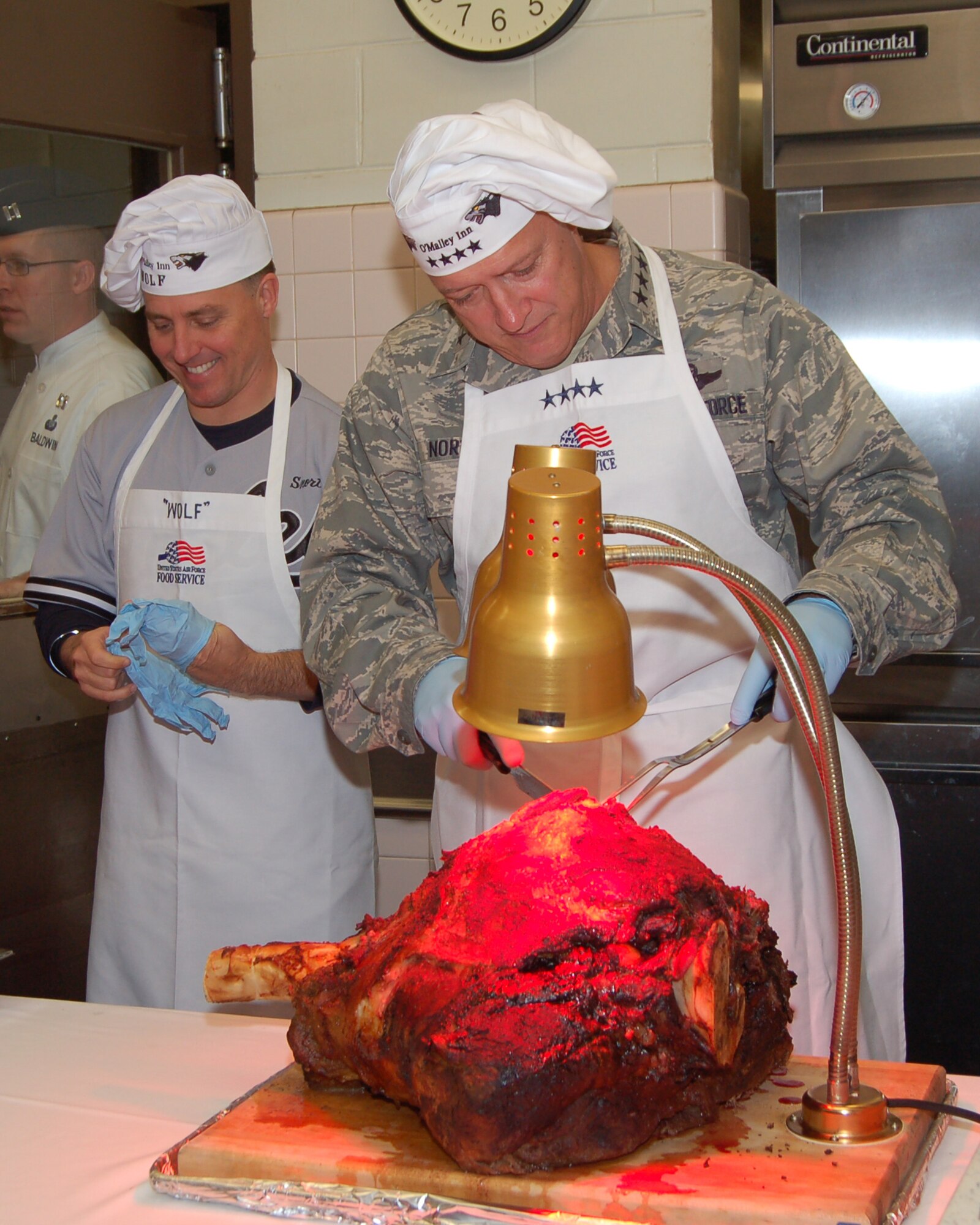 KUNSAN AIR BASE, Republic of Korea--Col. Robert Givens, 8th Fighter Wing commander, and Gen. Gary North, Pacific Air Forces commander, prepare to serve Thanksgiving dinner to Airmen at the O’Malley Dining Facility here 26 November.  Gen. North visited Kunsan with senior leaders from PACAF and the 7th Air Force and members of the PACAF Civilian Advisory Council to help serve the holiday meal and dine with Wolf Pack members.  Airmen serving at this remote assignment enjoyed a meal and conversation with leadership. (U.S. Air Force photo/Master Sgt. Anna Hayman)