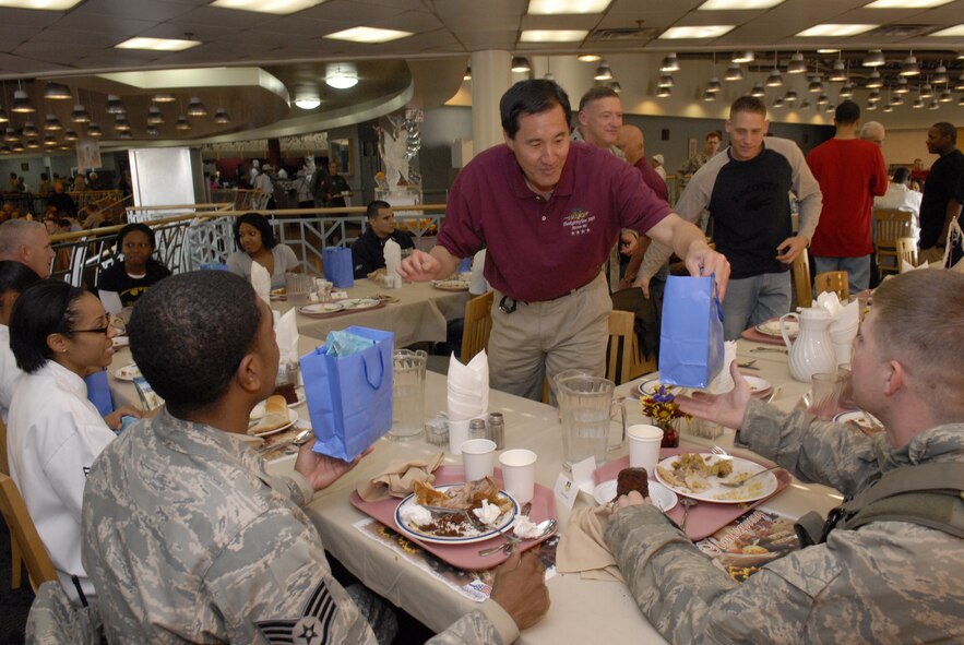Steven Ai, a member of the Air Force Civilian Advisory Council, passes out gifts to 8th Fighter Wing Airmen at Osan Air Base, Republic of Korea, Nov. 26. Gen. Gary North, Pacific Air Forces commander, Chief Master Sgt. Brooke McLean, PACAF command chief, and four AFCAC members visited but Kunsan and Osan Air Bases, ROK, to celebrate Thanksgiving with the Airmen serving in the ROK. (U.S. Air Force photo/Tech. Sgt. Jerome Tayborn)