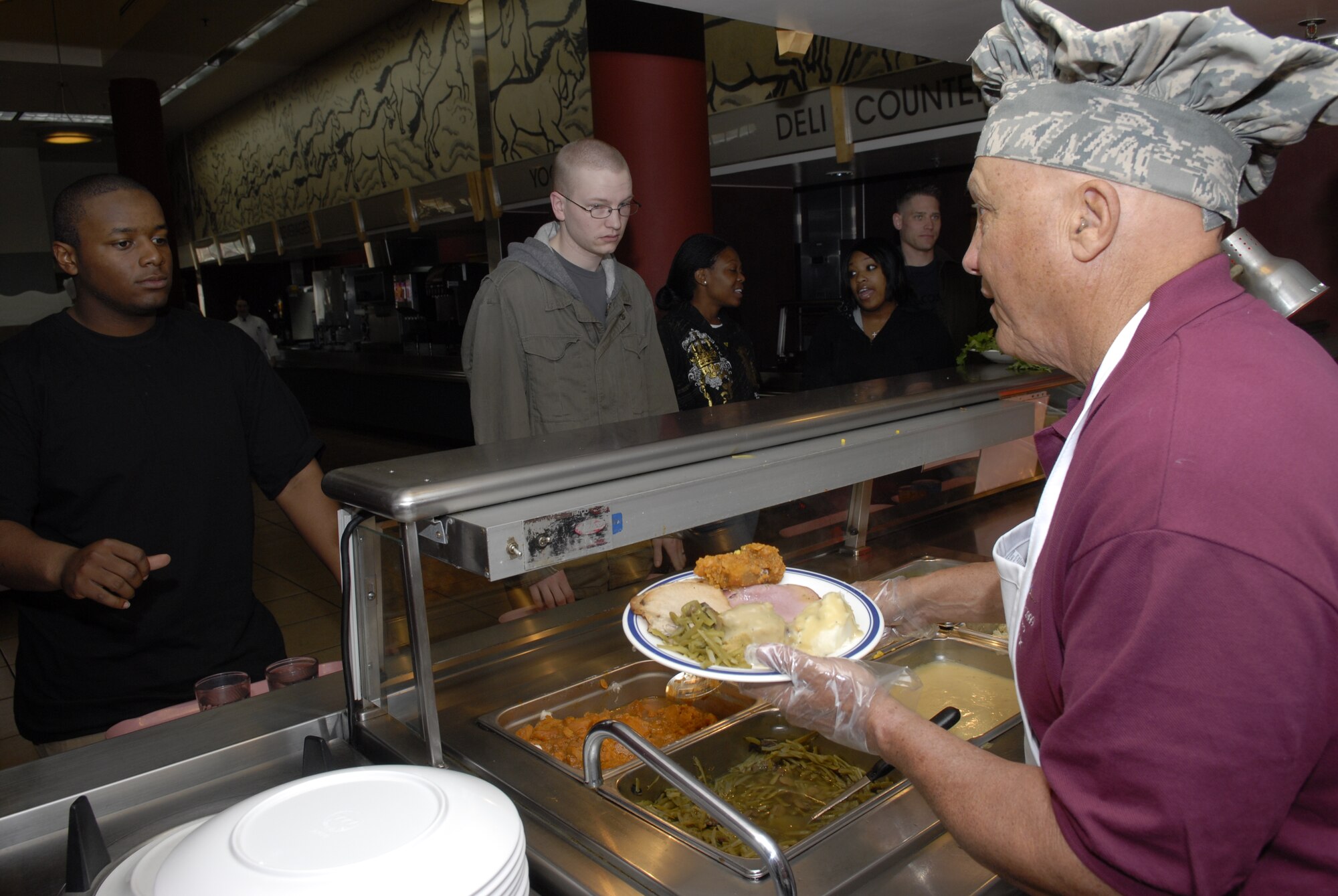 Anthony Guerrero Jr., a member of the Air Force Civilian Advisory Council, serves up a hot Thanksgiving meal to Private 1st Class Evan McBride, Delta 652 Air Defense Artillery, Nov. 26 at Osan Air Base, Republic of Korea. General  North, Chief Master Sgt. Brooke McLean, PACAF command chief, and four members of AFCAC visited but Kunsan and Osan Air Bases, ROK, to celebrate Thanksgiving with the Airmen serving in the ROK. (U.S. Air Force photo/Tech. Sgt. Jerome Tayborn)