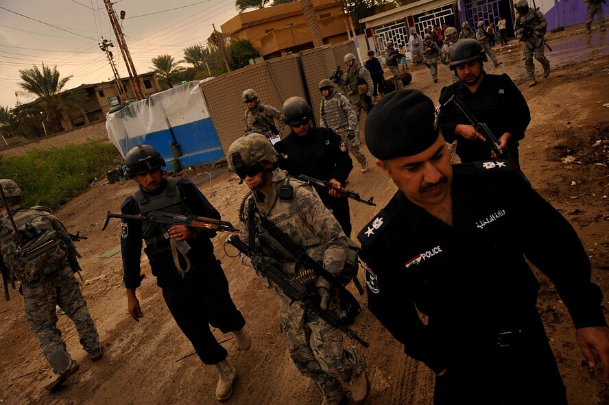 U.S. Air Force Airmen from the 732nd Expeditionary Security Forces Squadron Det. 2, deployed to Baghdad, Iraq, conduct a foot patrol through a Baghdad neighborhood, along with their counterparts from the Iraqi Police, in an effort to assess local checkpoints set up by the Iraqi Police, Nov. 19, 2009. (U.S. Air Force photo/Staff Sgt. Angelita Lawrence)